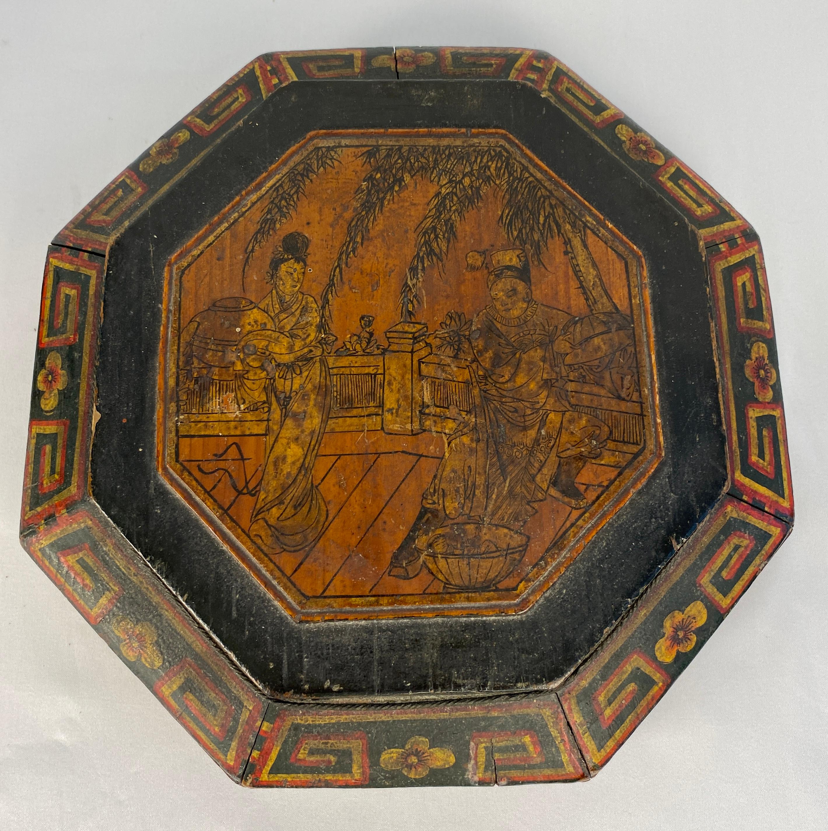 An antique Chinese lunch box from the early 20th century, with a carved handle. 

Crafted in China during the early years of the 20th century, this lunch basket features a lid adorned with hand-painted figures, hand-carved elements. The lacquered