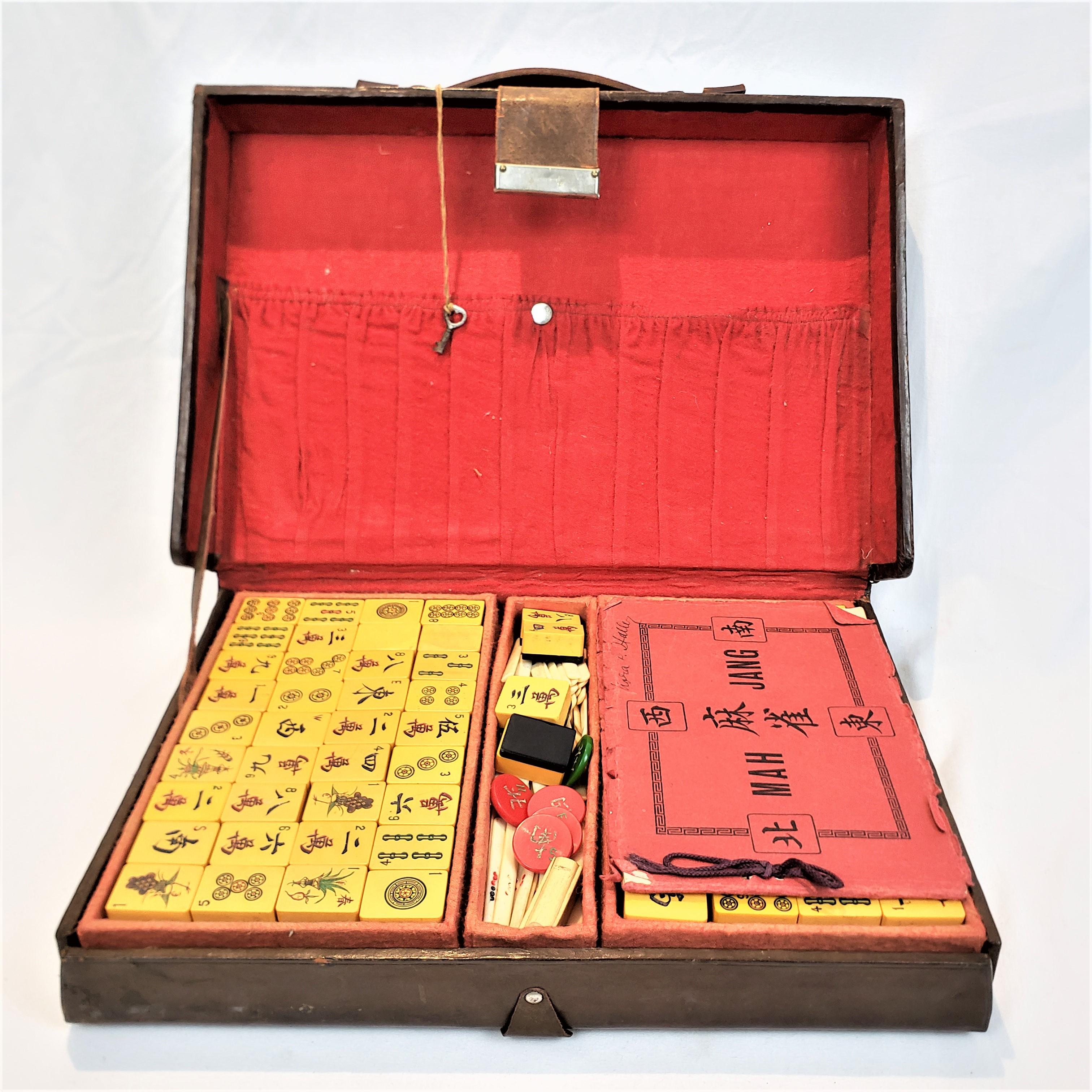 This antique Mahjong set is presumed to have originated from China and date to approximately 1900 and done in the Chinese Export style. The tiles are composed of a butterscotch bakelite and some with black backs, with etched and hand painted