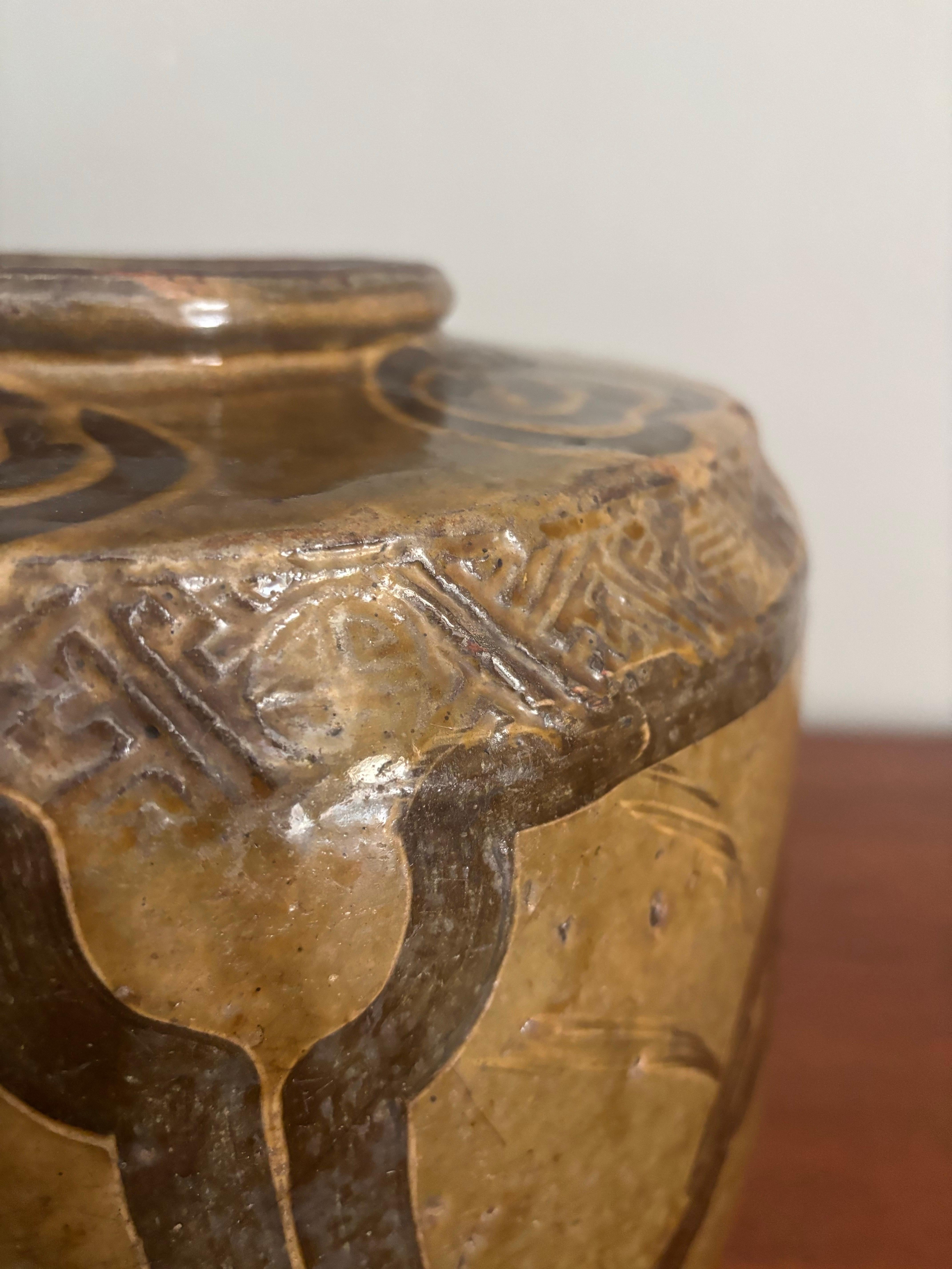 Beautiful example of an antique Chinese Martaban style jar from the 19th century. Terracotta with an olive hand applied glaze. In the glaze is also hand painted symbols, flowers and a bird. 

Large shape with high shoulders. Was used for spices and