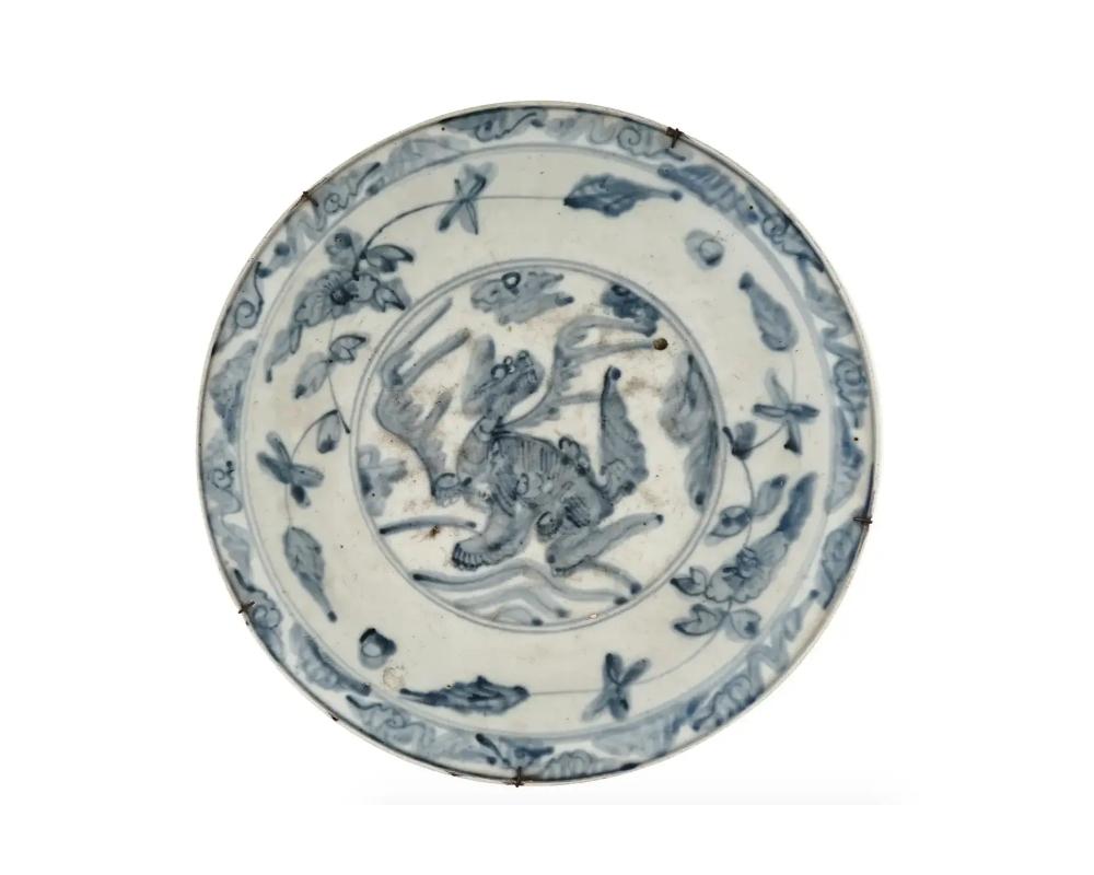 Ancienne assiette ou chargeur en porcelaine bleue et blanche peinte à la main à l'époque Meiji. Circa : fin du 19e siècle au début du 20e siècle. Le chargeur est orné d'une image peinte à la main sous glaçure d'un dragon entouré de motifs floraux et