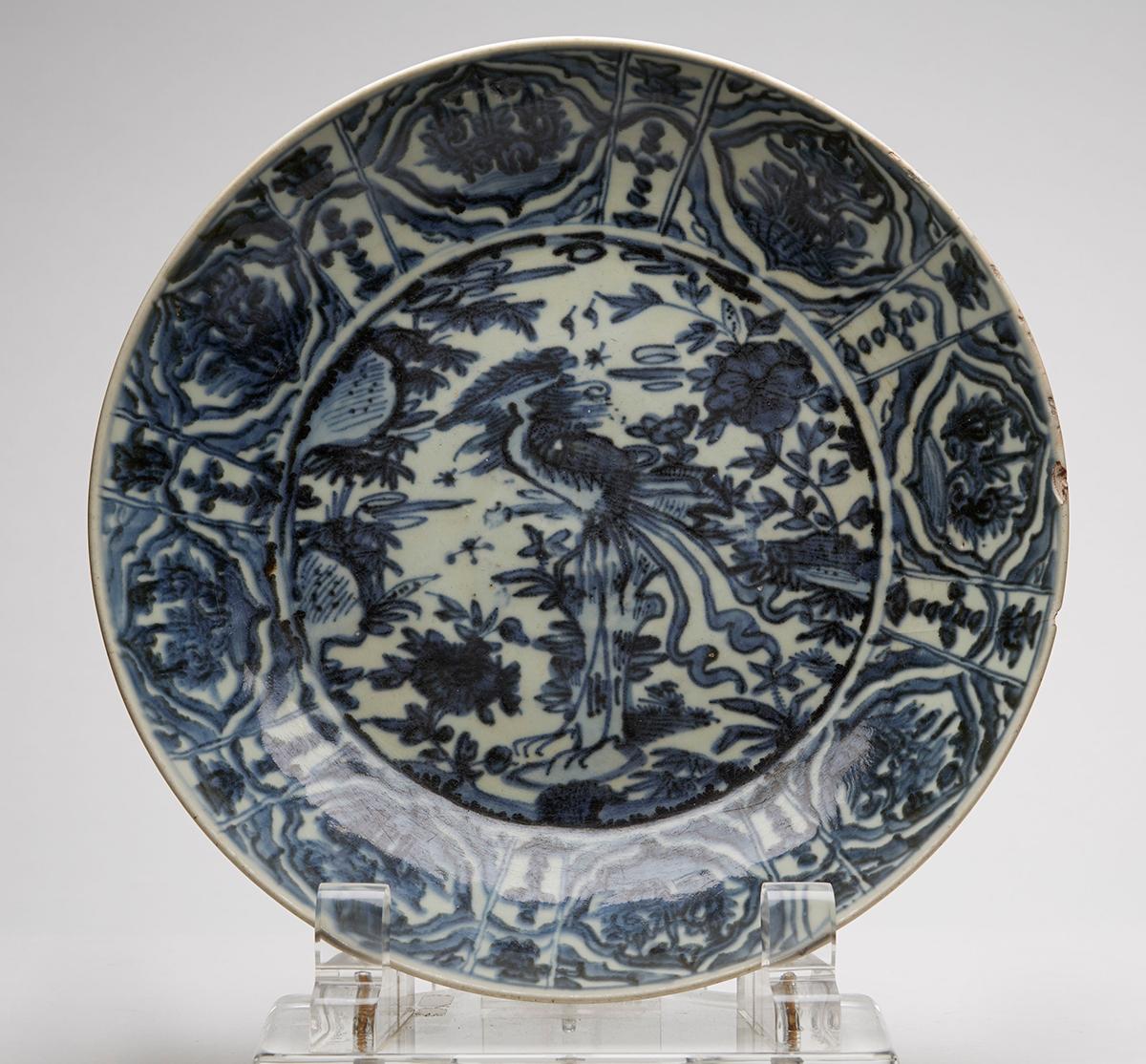 A stunning large antique Chinese Zhangzhou (Swatow) blue and white shallow porcelain dish of rounded form decorated centrally with a standing phoenix bird set amidst flowering blooms and rocks with flying insects with eight floral panels set between