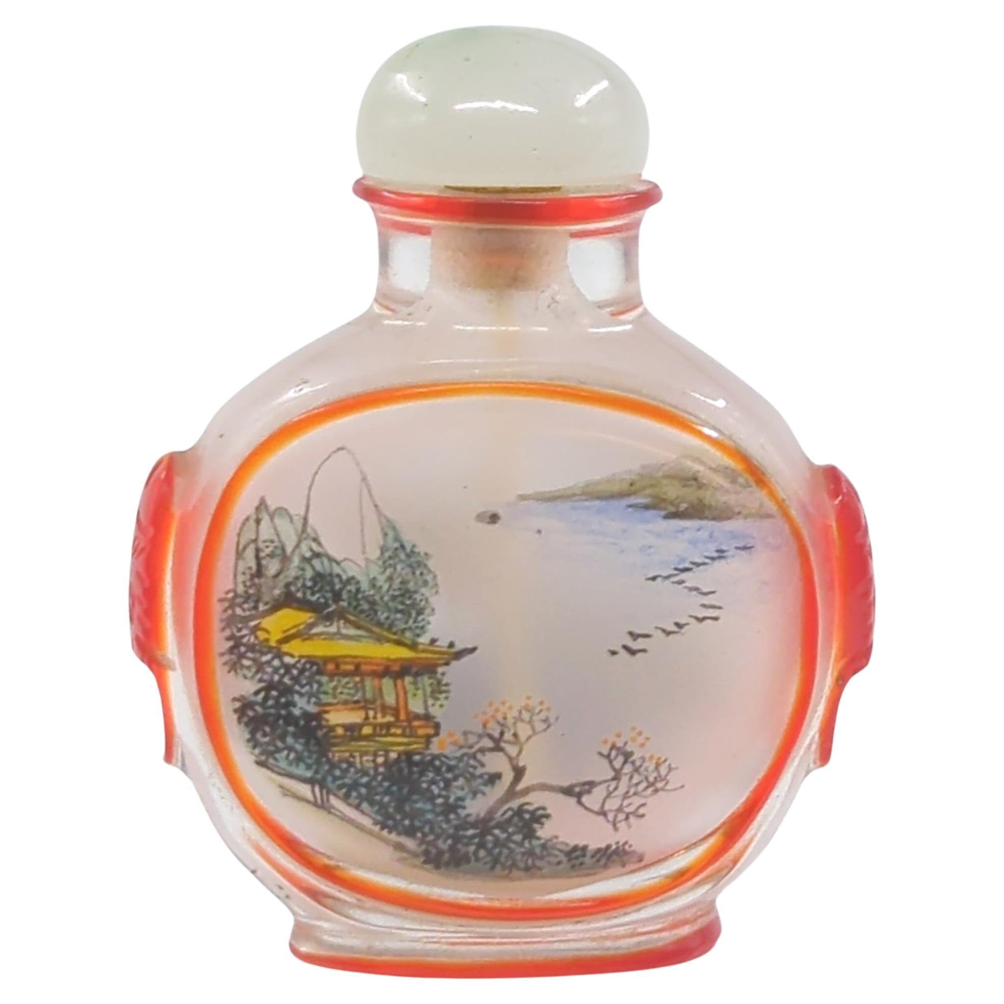 Vintage Chinese inside painted glass mini snuff bottle,  masterfully reverse hand painted a lotus blossom scene to one side, and a landscape scene to the other side, raised on an overlay bordered flat footring, and with stylized overlay beast and