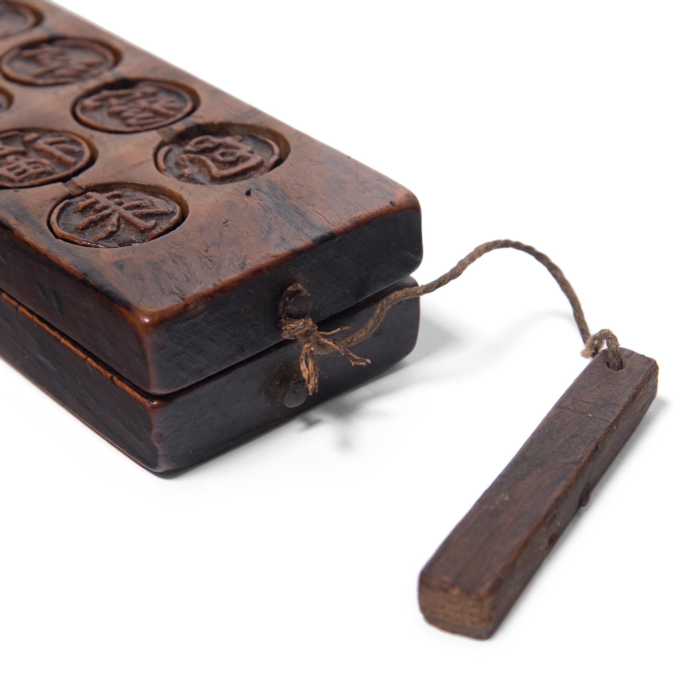 Dated to the mid-19th century, this rustic wood press is carved with twenty round molds used for shaping festive mooncakes. Packed with lotus root, red bean, or other regional fillings, mooncakes are a delicacy eaten during the Mid-Autumn Festival