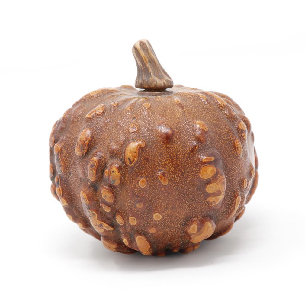A Natural Gourd Snuff Bottle, Qing Dynasty. A  dried globular knobby gourd that is hollowed, lacquered and buffed to serve as a snuff bottle with an inserted and affixed narrow ceramic collar. The stopper is made of a natural gourd stem as the