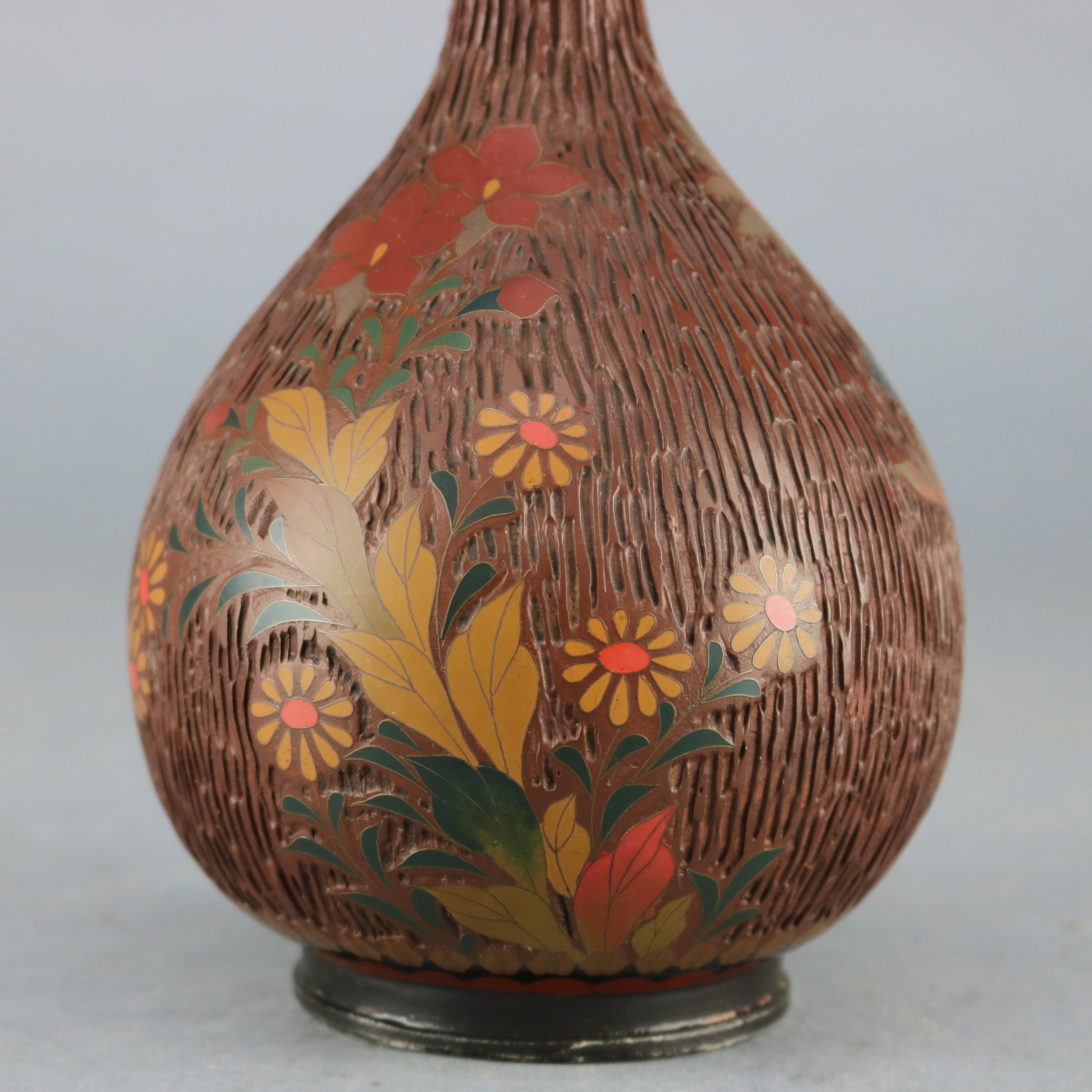An antique Chinese Cloisonne bud vase offers enameled metal construction all-over textured wood bark design with decorated collar, elements of the Naturalist Movement, circa 1990. 

Measures: 11.75