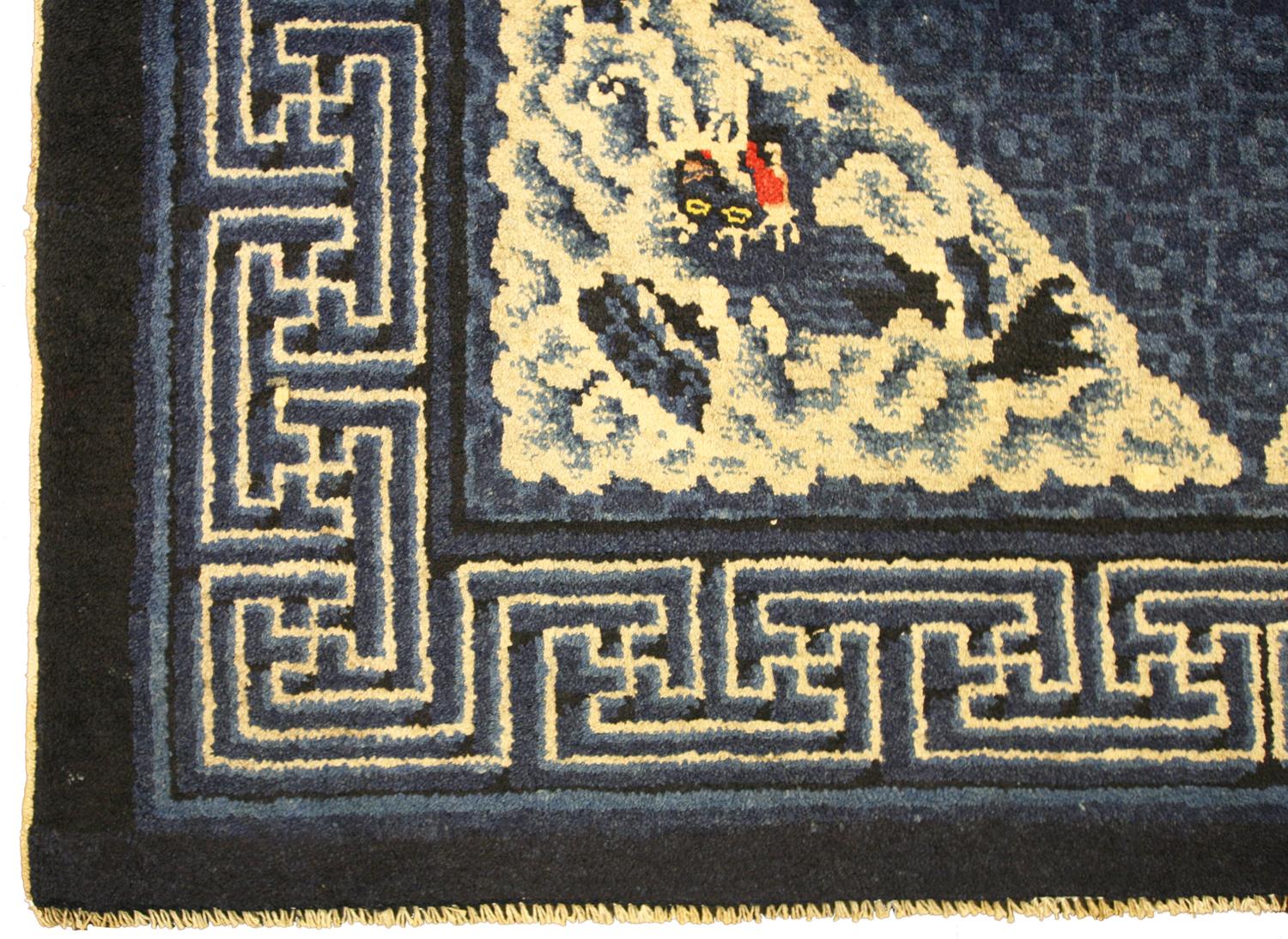 Cet ancien tapis chinois Ningxia au motif de dragon flottant est une véritable œuvre d'art. Ce motif complexe représente des dragons et des nuages dans des tons de bleu, de blanc et de blanc cassé. Le tapis est fabriqué en laine de haute qualité, ce