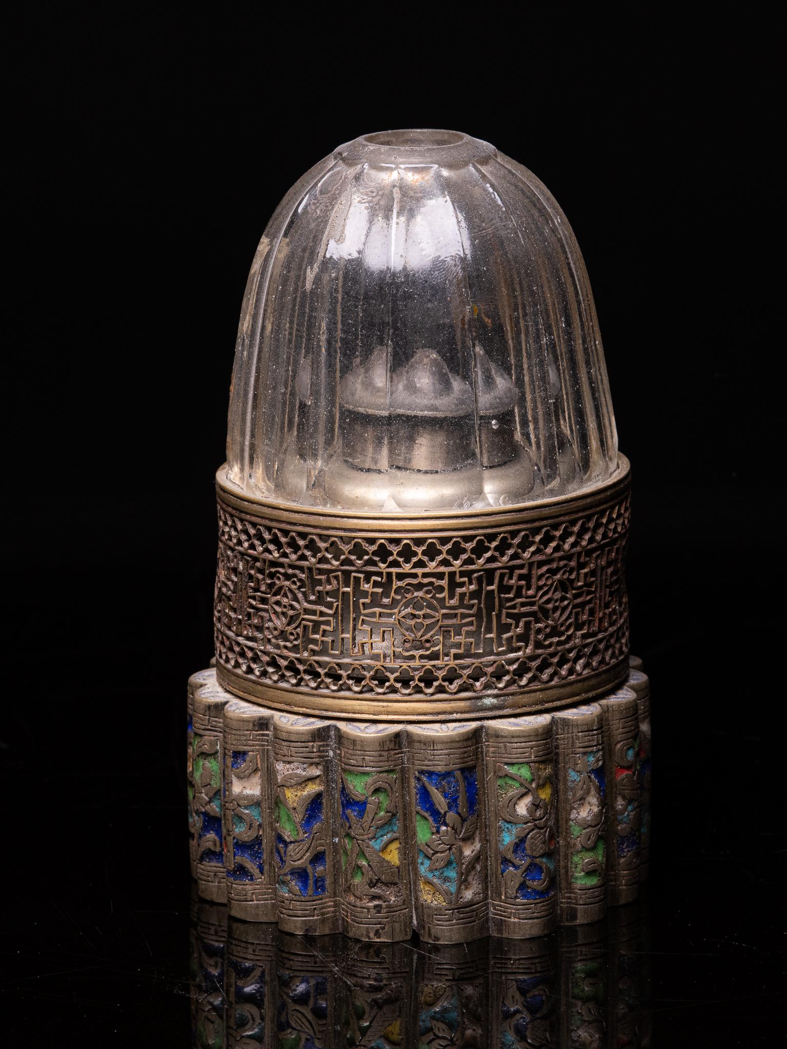 Spectacular Antique Chinese Opium Lamp with a Round Silver Base that is Multi-lobed and elaborated in Cloisonné. The Copper Lamp Glass Holder is perforated. The Lamp Glass is made of Colorless Glass with Facets. 
Opium smokers used opium lamps to