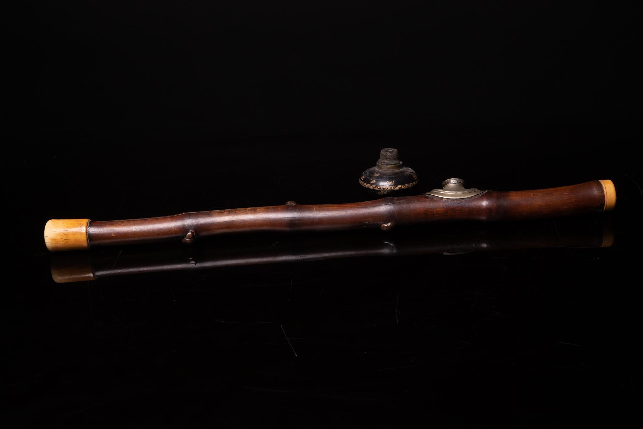 The opium pipe is used to vaporize and inhale opium. The pipe consists of a long stem of almost half a meter, a ceramic pipe bowl, and a metal fitting (“saddle”), through which the pipe bowl plugs into the pipe stem. The pipe is heated over a unique