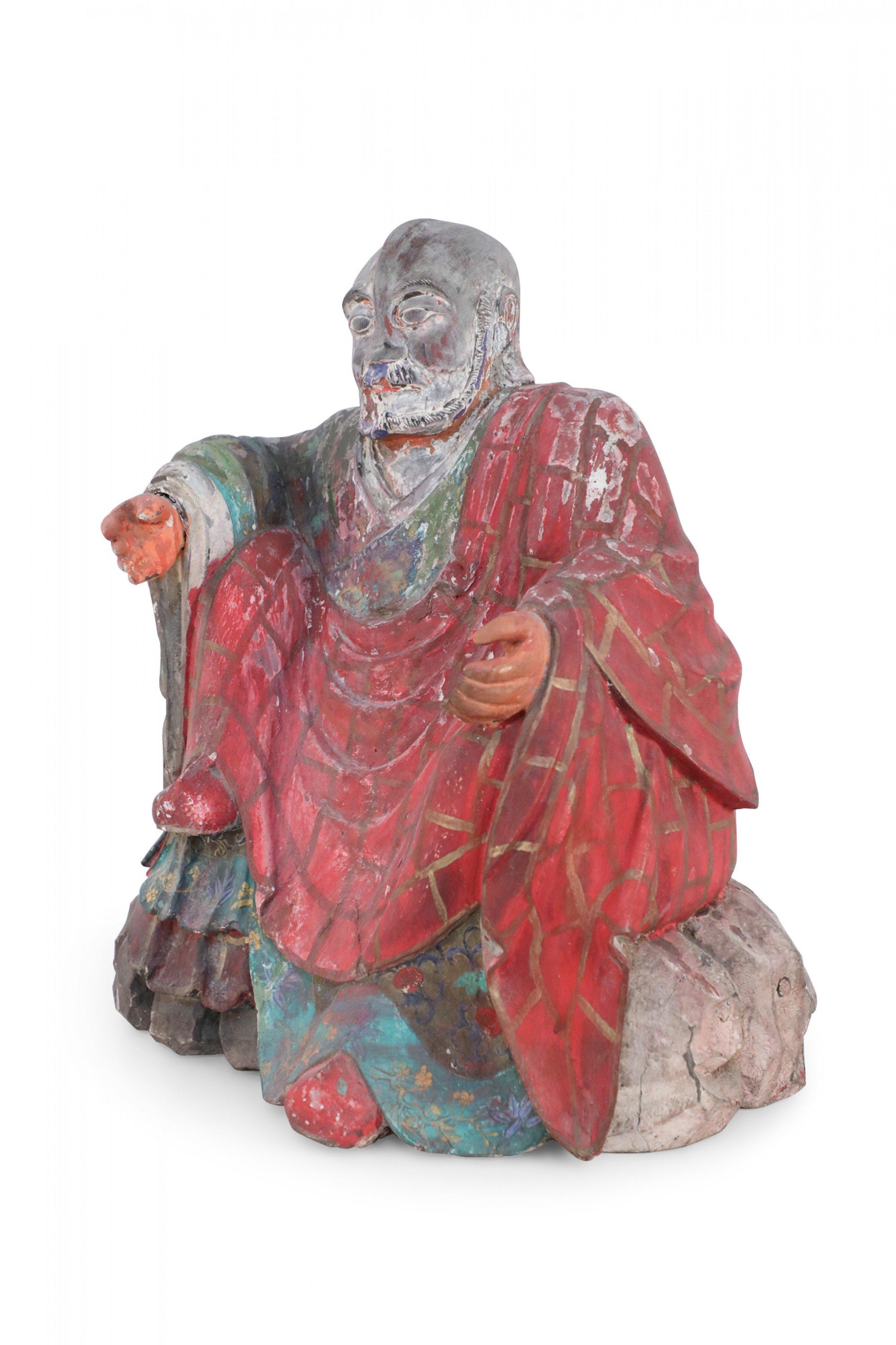 Antique Chinese (early 20th Century, Republic of China) clay Buddha sculpture with painted details and red and green robes.
 
