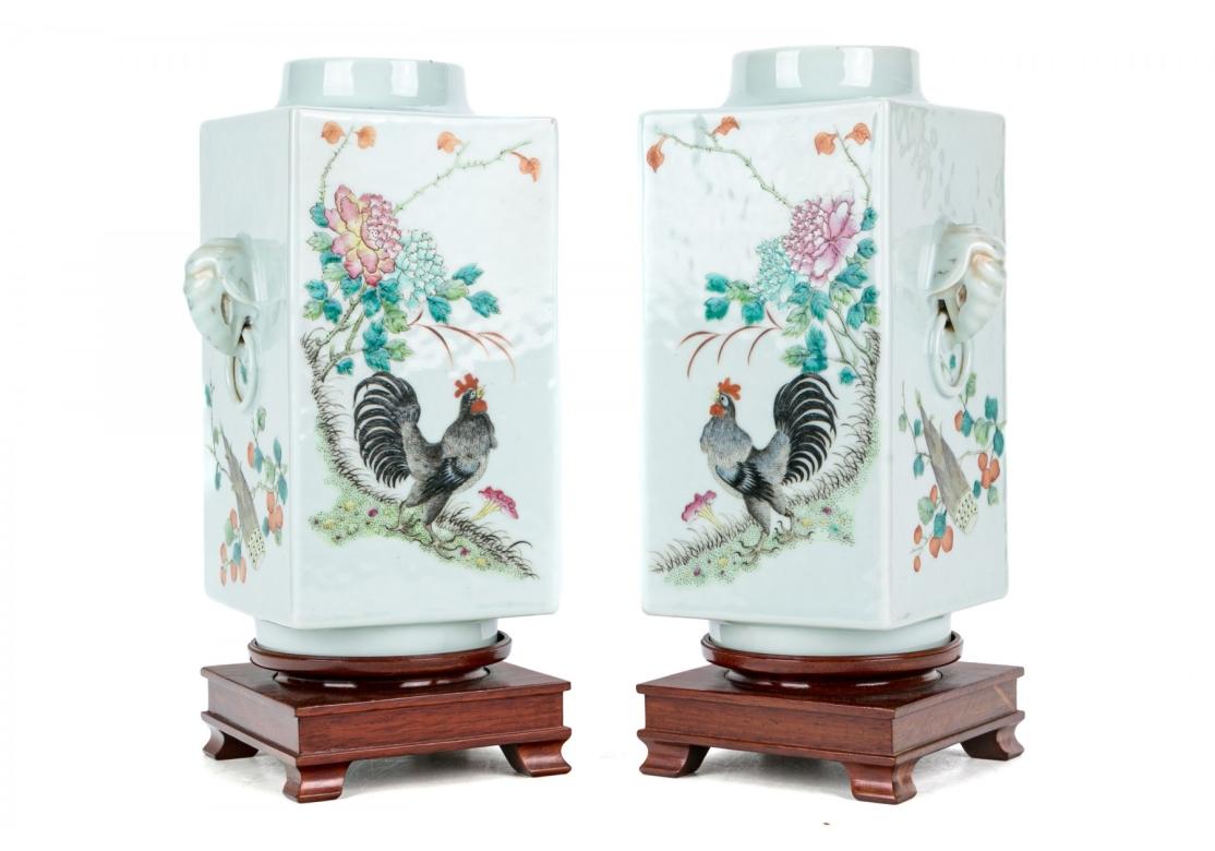 An exceptional antique pair of Chinese famille rose enameled porcelain archaistic “Cong” form vases, on fitted wood stands. 
The archaistic, squared 