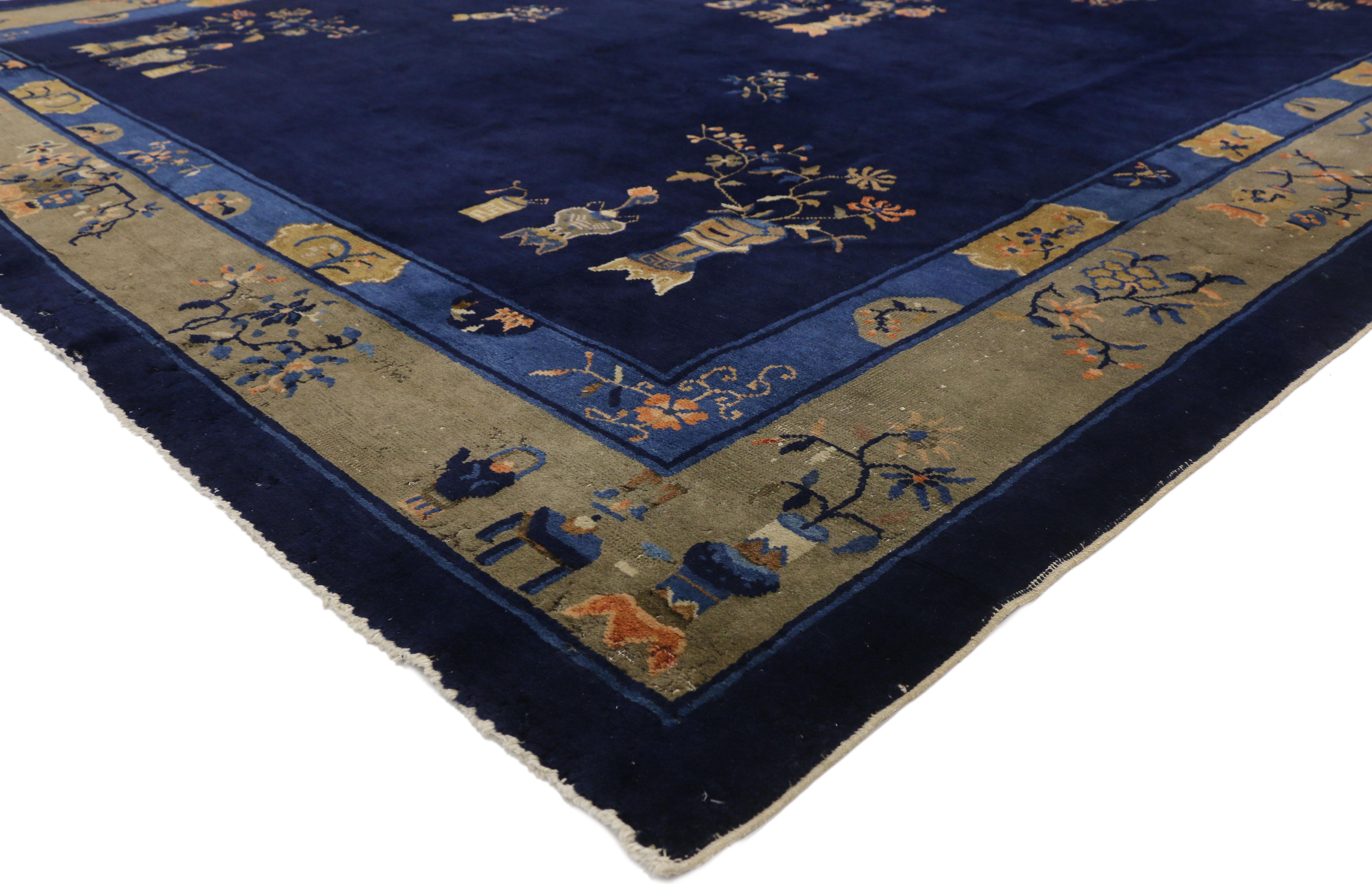 77260 Antique Chinese Peking Area rug with Traditional Chinoiserie style. This hand knotted wool antique Chinese Peking area rug features a group of three flowering cloisonne vases floating in an open abrashed indigo navy blue field. The number