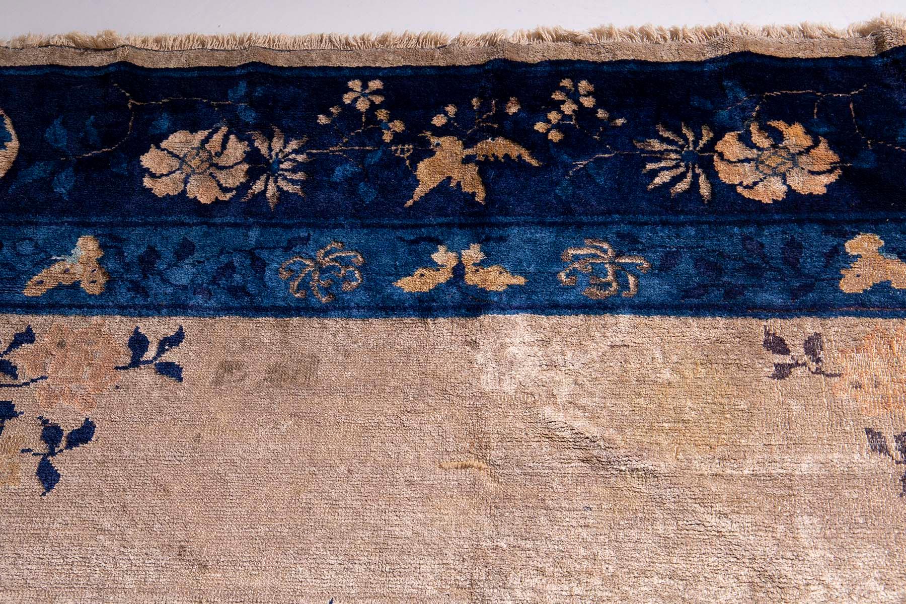 In der Stille eines schwach beleuchteten Raumes liegt ein Schatz aus einer anderen Zeit - ein antiker chinesischer Peking-Teppich, ein Zeugnis der Handwerkskunst und der Kunstfertigkeit, die die Zeiten überdauert. Aus der Zeit um die