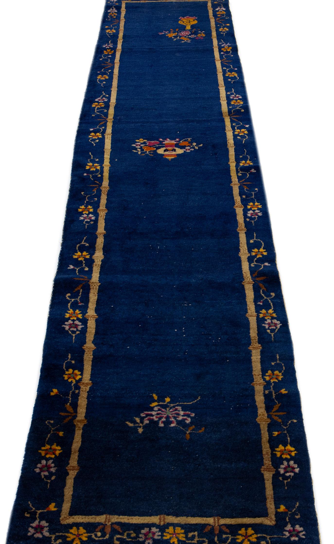 Magnifique chemin de table en laine nouée à la main, de style chinois pékinois, avec un champ bleu marine. Ce tapis chinois présente des accents multicolores dans un magnifique motif floral chinois. 

Ce tapis mesure : 2'5