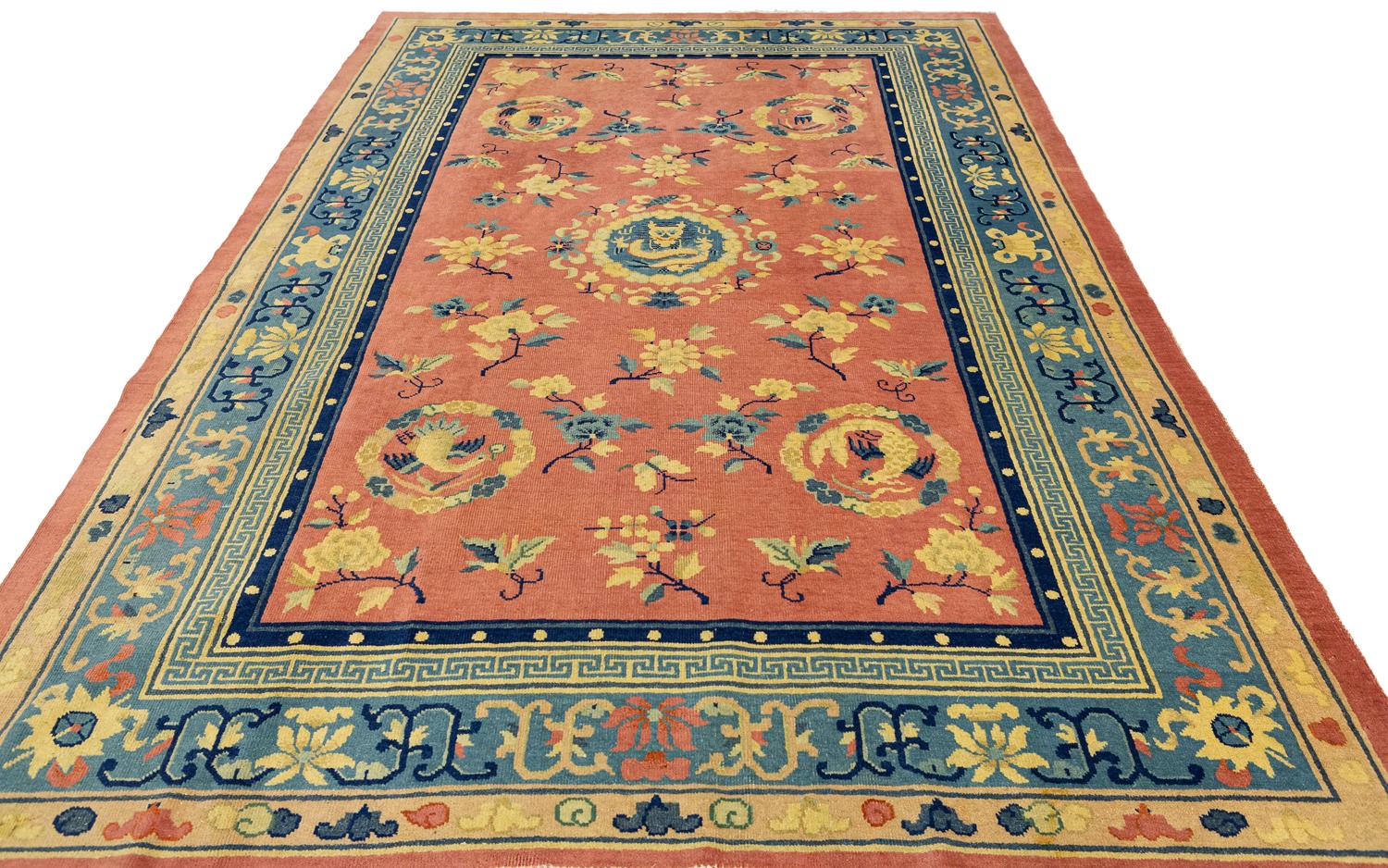 This is an antique pecking Chinese rug woven in during the beginning of the 20th century circa 1920s. it has an all-over field design comprised of blossoming tree branches with four bird motifs located in each of the corners of the rug which are