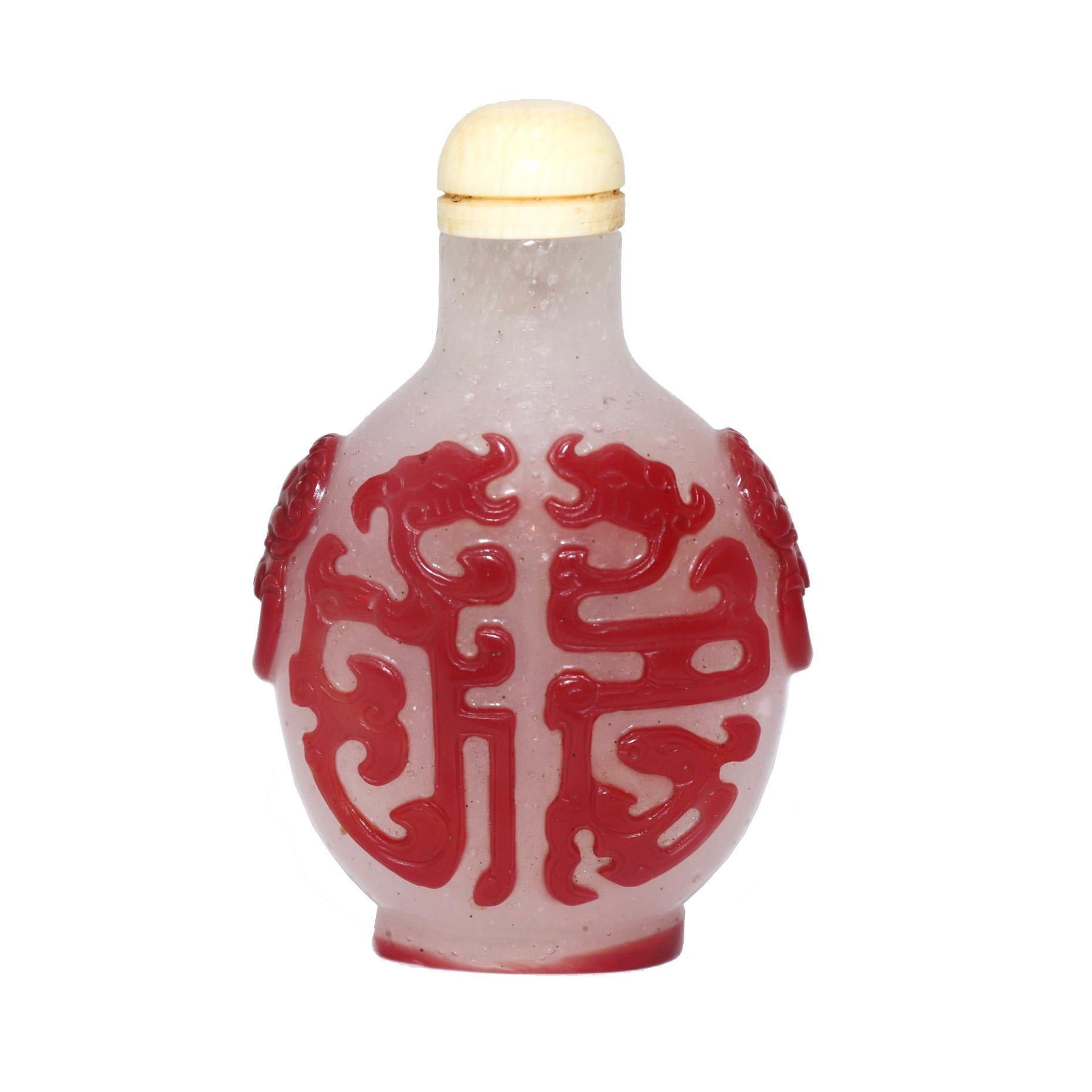 Antique Chinese Peking Red Overlay Snowflake Glass Snuff Bottle, of flattened ovoid shape with sloping shoulders, round neck, thin and flat mouth rim, raised oval foot and countersunk base, fine detailed carved decoration of archaistic kui dragons