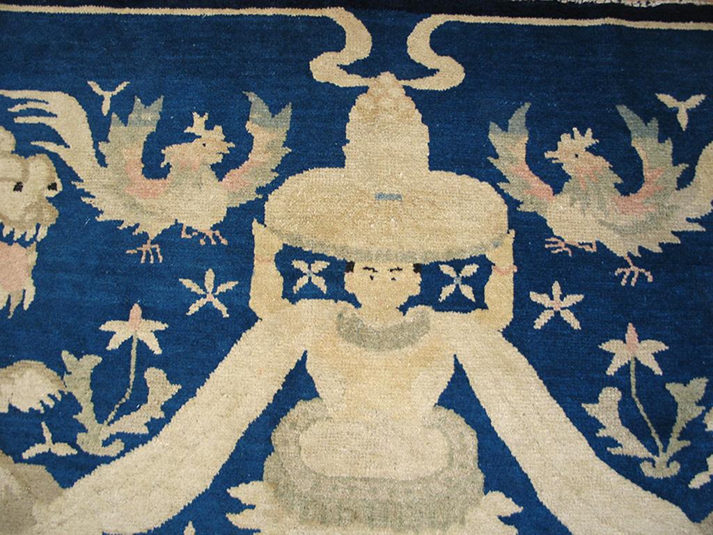 This extraordinary borderless rug displays two facing, seated fierce lion-dogs guarding a central human statue figure bearing a smoking incense burner. Two roosters flutter above. The tonality is Classic blue and white on this northeastern Chine