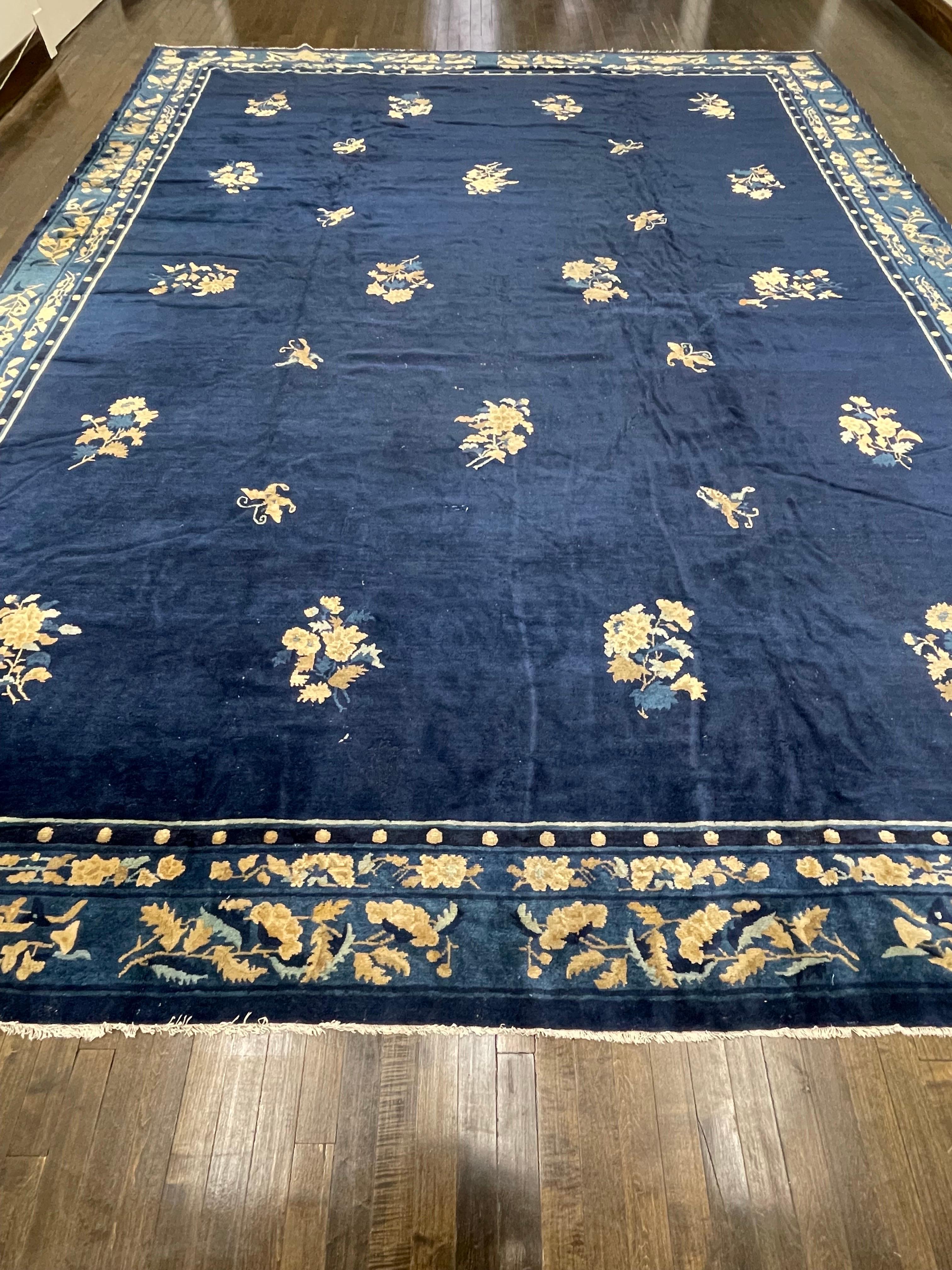 Tapis chinois classique du XIXe siècle au champ peu décoré, ce tapis est tissé à la main avec des nœuds très fins sur un champ bleu indigo rare. Connu sous le nom de chinois de Pékin, ce tapis est encadré d'une bordure spectaculaire.

La laine