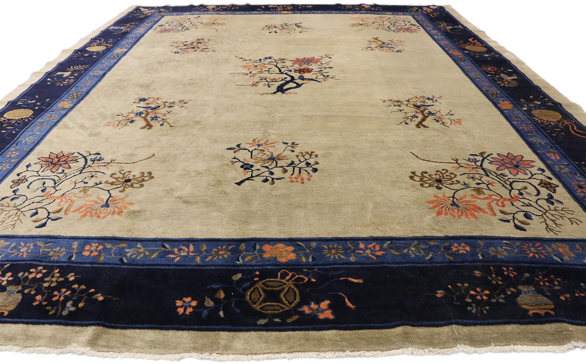 77230 Antique Chinese Peking Rug, 09'00 x 11'04. 
This hand knotted wool antique Chinese Peking rug features a variety of elegant floral motifs spread across a cream field. Each of the floral motifs depicts a tree in bloom with four different types