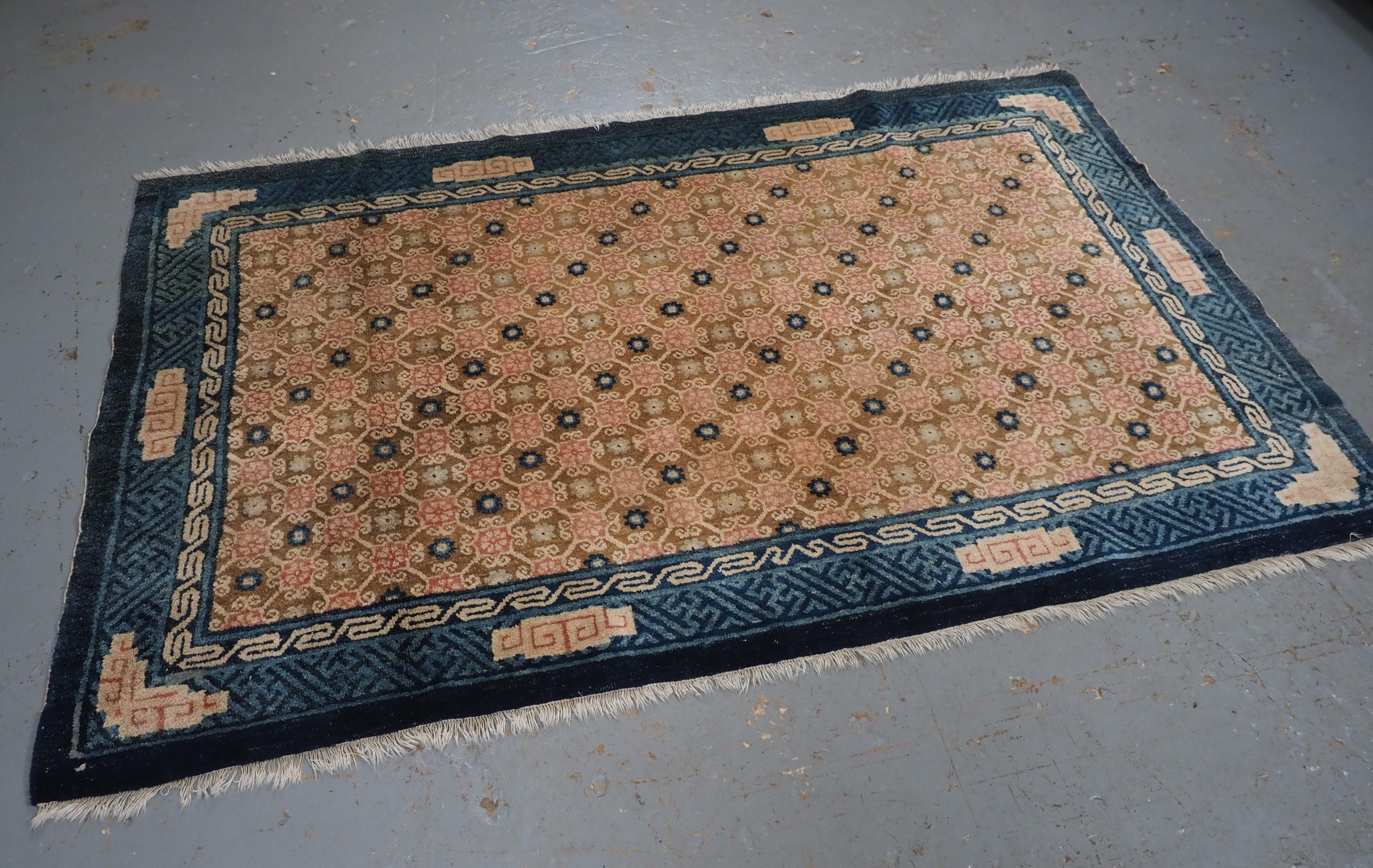 Size: 4ft 2in x 6ft 6in (126 x 198cm).

Antique Chinese Peking rug with lattice design.

Circa 1900.

A very good example of a lattice design with floral blossom in pinks and blue on a soft beige ground. The rug is framed by a blue border with