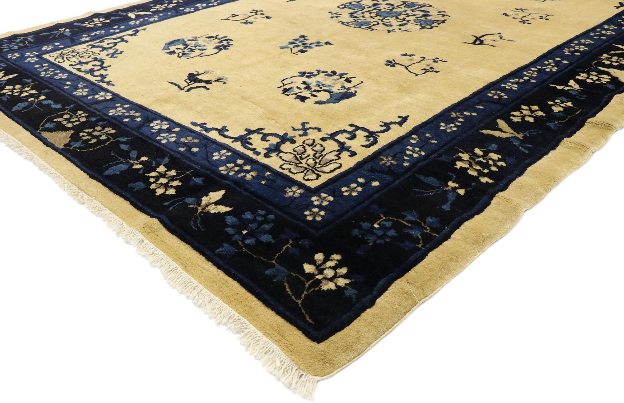 77446 antique Chinese Peking rug with Romantic Chinoiserie style. This hand knotted wool antique Chinese Peking rug features a round open center medallion with blooming lotuses across an abrashed ecru field. Bats, peonies, chrysanthemums and leafy