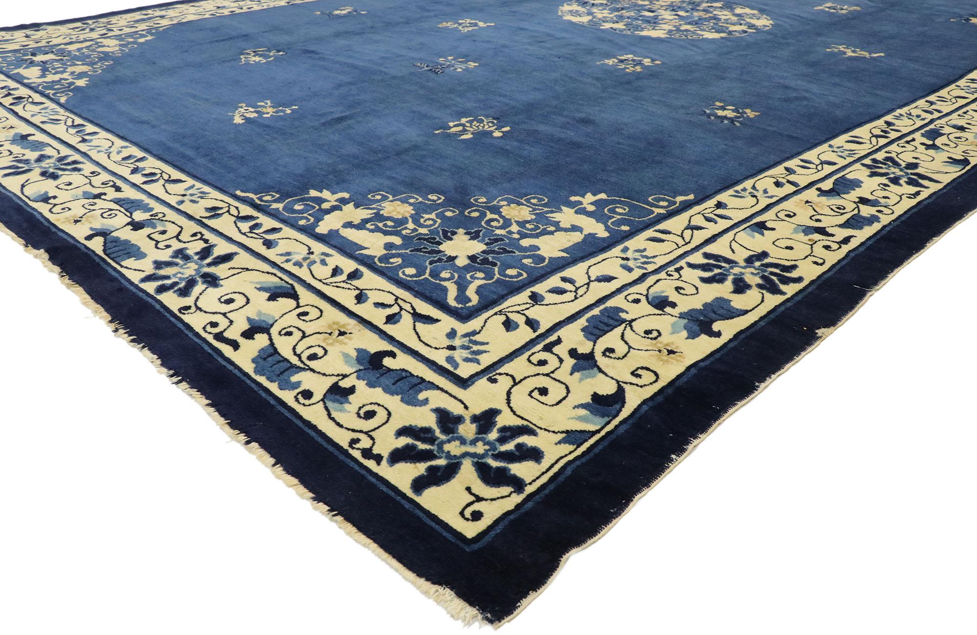 77442 antique Chinese Peking rug with Romantic chinoiserie style. This hand knotted wool antique Chinese Peking rug features a rounded open center medallion decorated with a swirl of peonies and leafy tendrils floating in the center of an abrashed