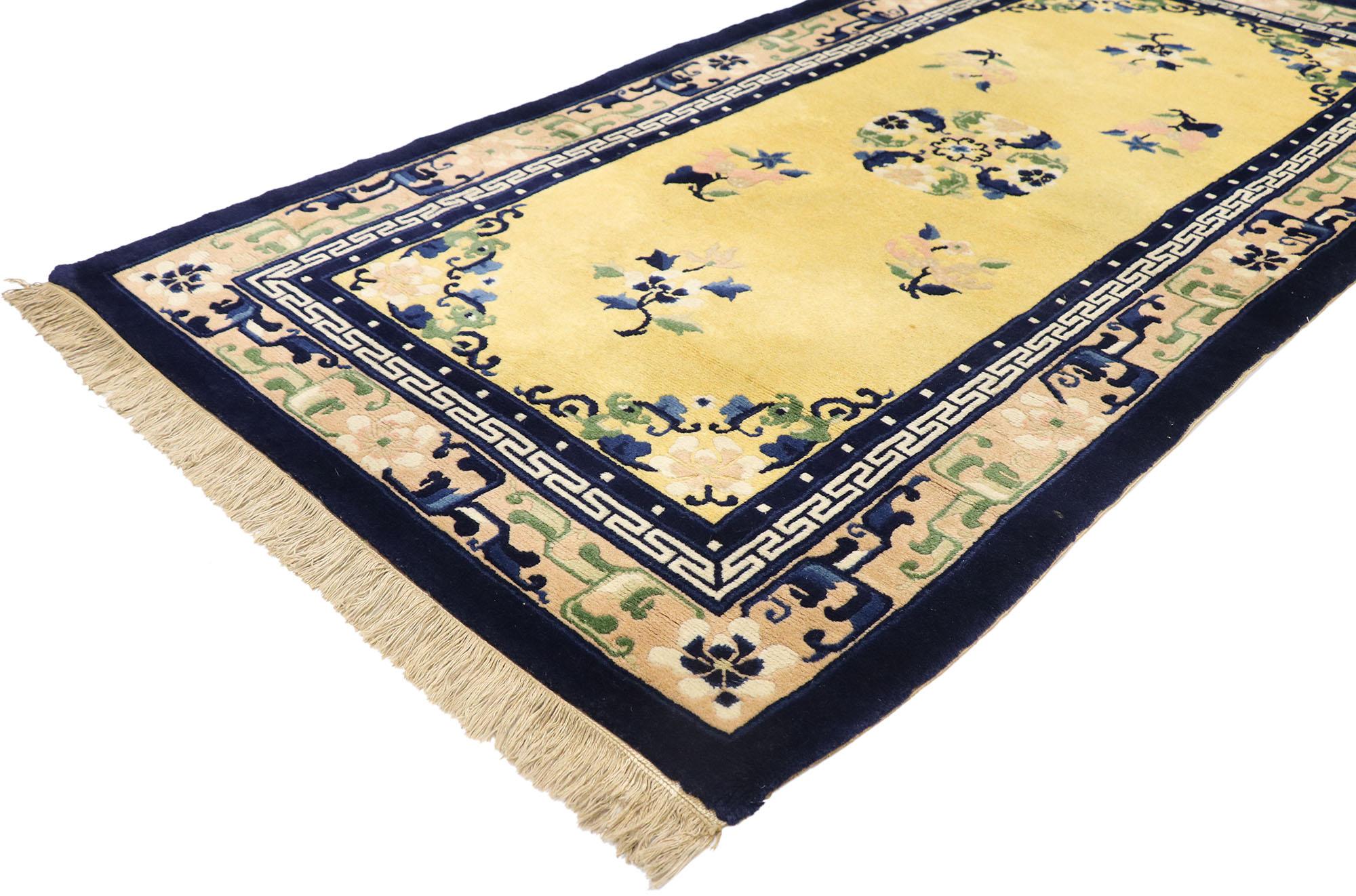 77590, antique Chinese Peking rug with Romantic Chinoiserie style. This hand knotted wool antique Chinese Peking rug features a rounded open medallion decorated with a lotus blossom, peonies, and leafy tendrils floating in the center of an abrashed