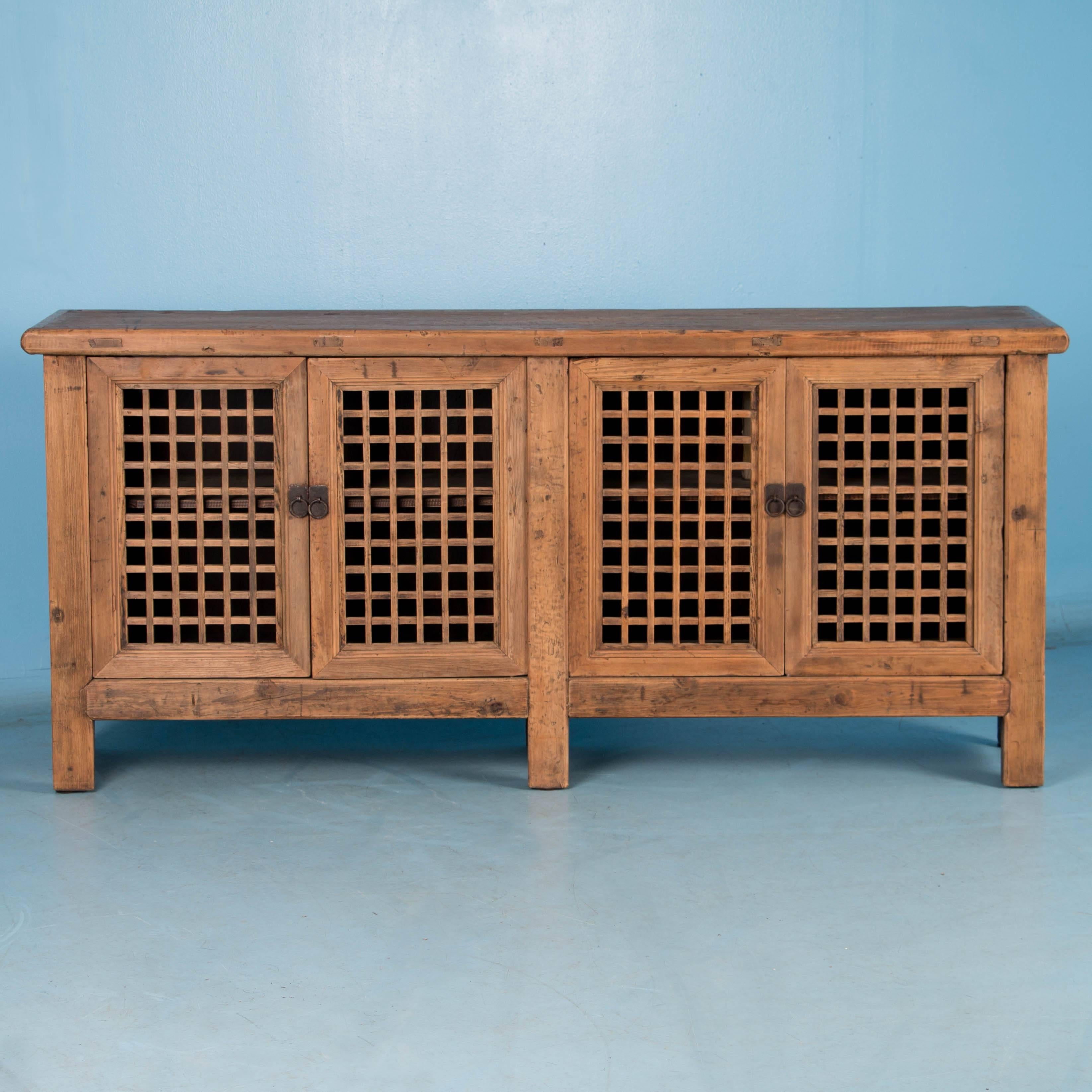 The raw wood creates an attractive organic look to this unique sideboard, while the four lattice work doors create visual appeal as well. Please examine the close up photos to appreciate the wood itself. Thanks to the size, this sideboard may also