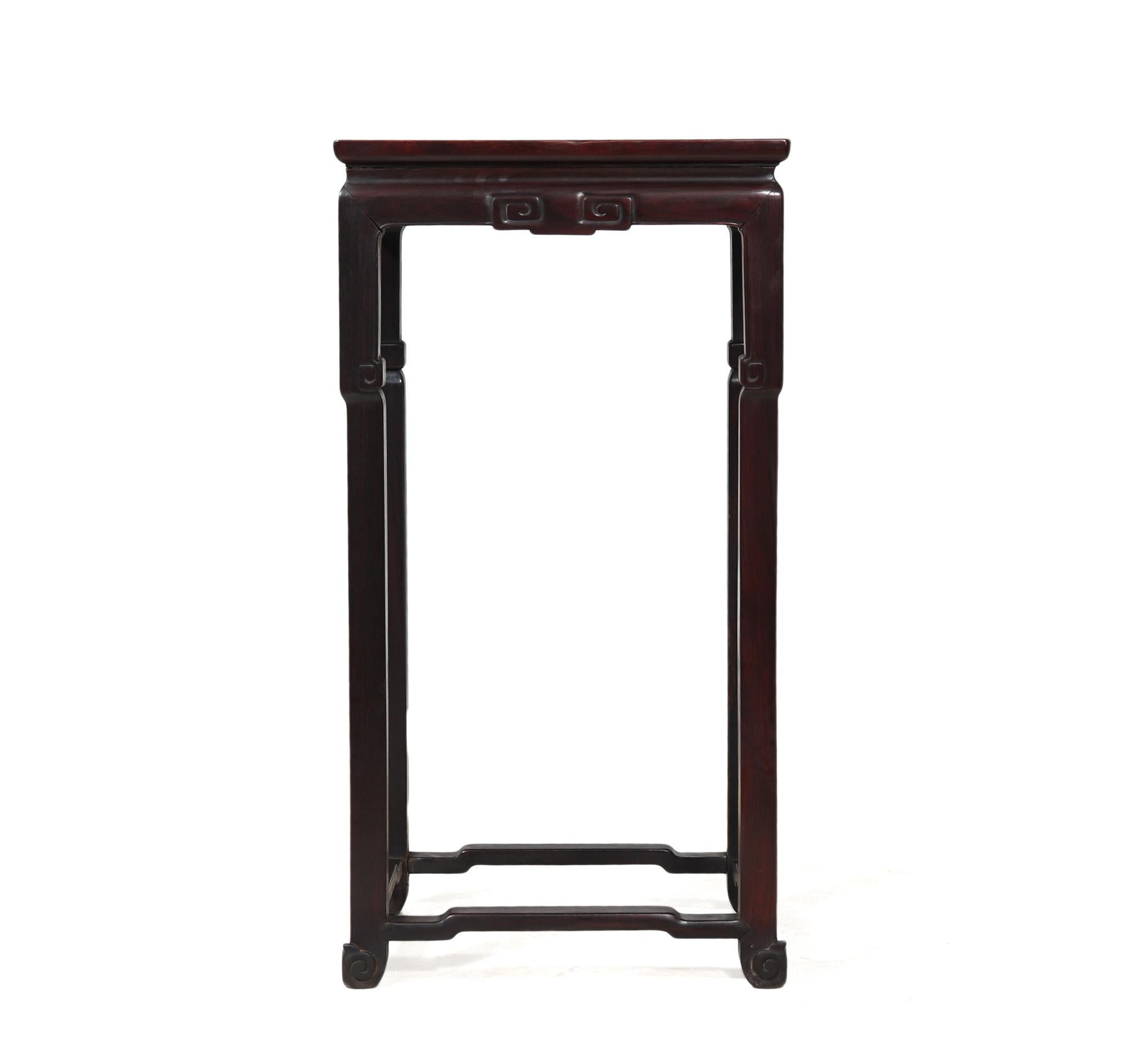 Antique Chinese Plant Stand Introducing this solid rosewood plant stand, carved to perfection in the timeless Ming style. This elegant piece features a slim line design with a waisted top and a beautifully carved skirt, adding a touch of