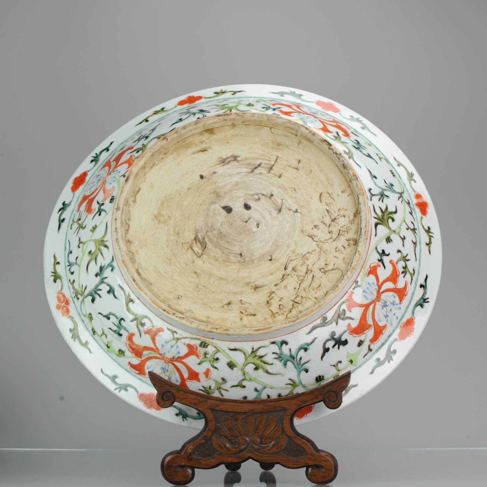 The wide, heavily potted dish is brightly enamelled to the centre with confronting phoenix surrounded with a lotus flower head meander, further encircled with the Eight Buddhist Emblems amongst auspicious clouds, the exterior with further lotus