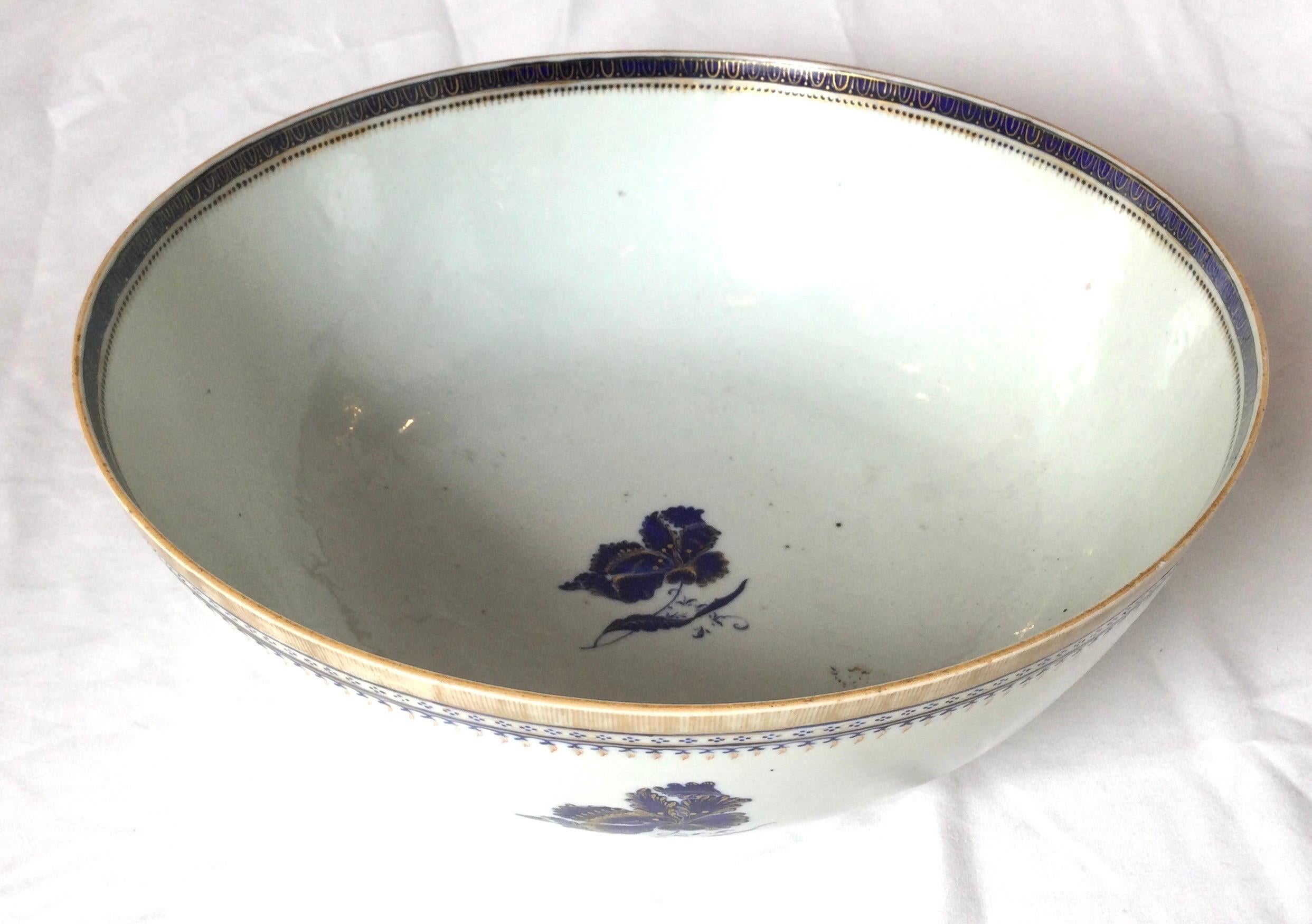 A Chinese porcelain blue and white bowl with gilt decoration. Circa 1850 with a white background, blue floral hand painted accents. Measures: 11.5 inches diameter, 4.5 inches tall.