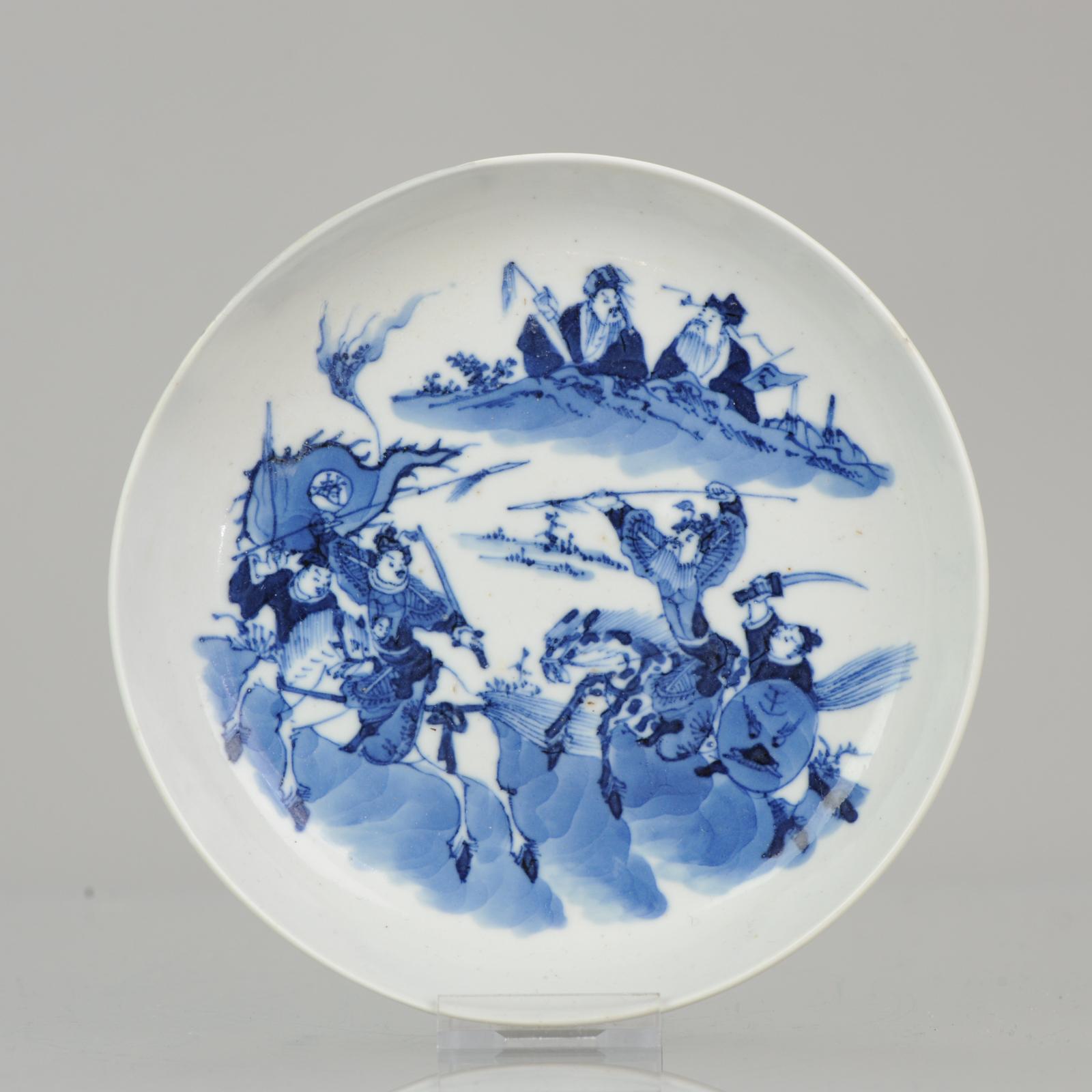 Description

A top quality small dish, Bleu de Hue porcelain. Central scene of 4 warriors in fighting position. 2 of them on horses, 2 walking. The left one is carrying a flag with some text. Above are two wise men watching the scene behind a