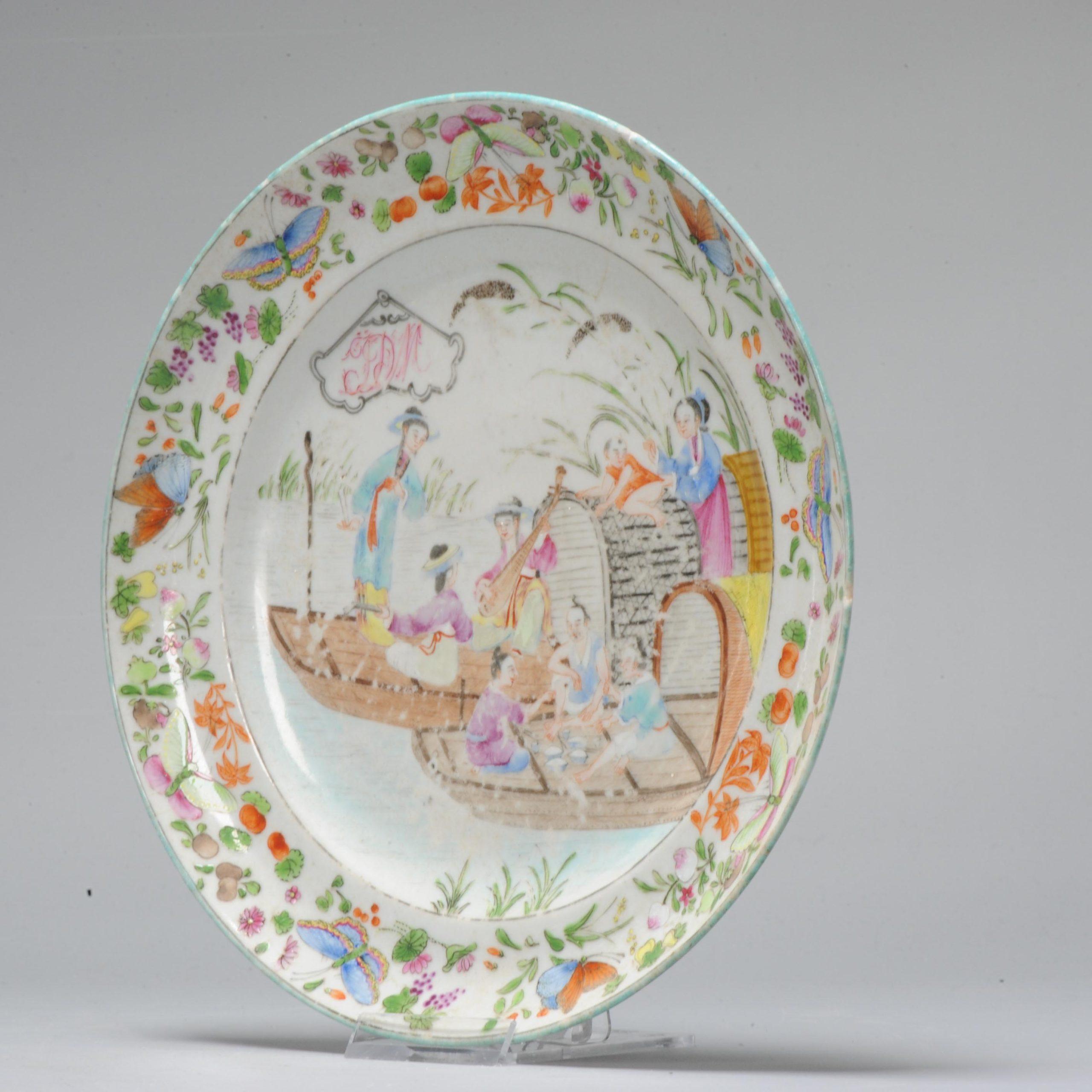 A very nice and unusual cantonese dish with armorial. Stunningly painted polychrome porcelain decorated with a river scene with boats and figures enjoying dinner and playing music. The border with a typical cantonese scene of flowers and