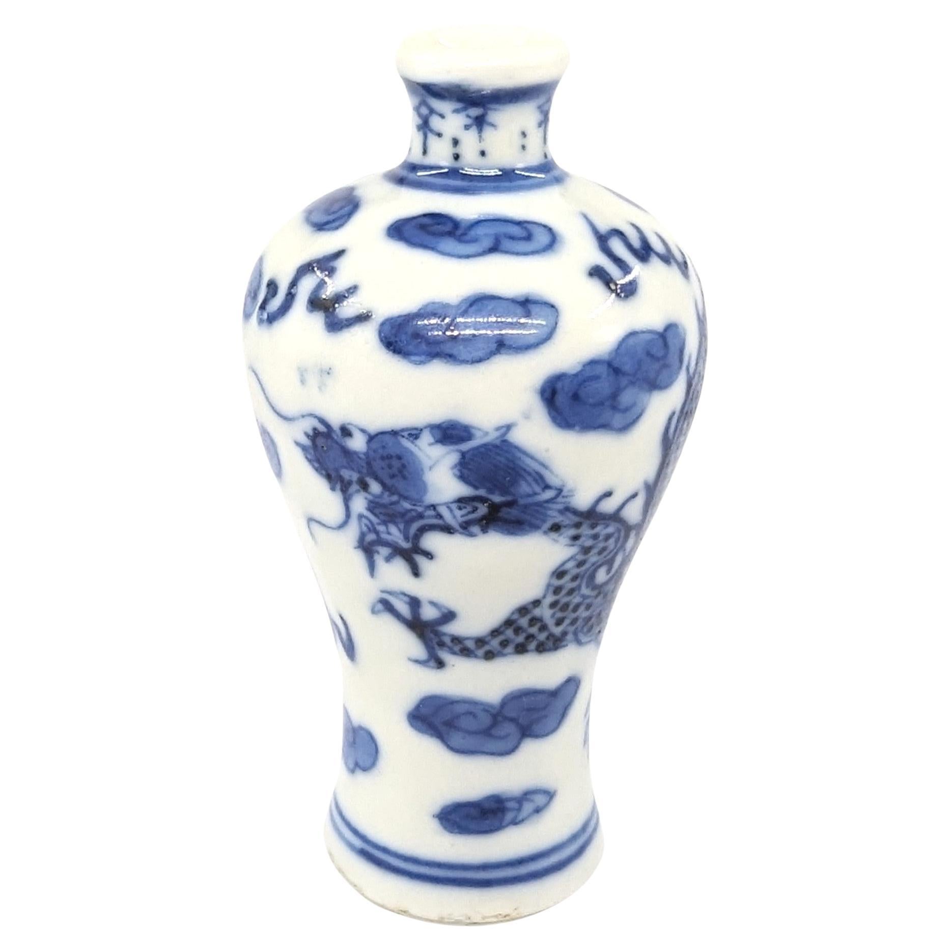 Ancienne bouteille à priser en porcelaine chinoise de forme meiping, peinte en bleu et blanc sous glaçure d'un dragon animé à quatre griffes poursuivant une perle parmi des nuages et des flammes.

Circa 1800, fin du 18ème au début du 19ème siècle,