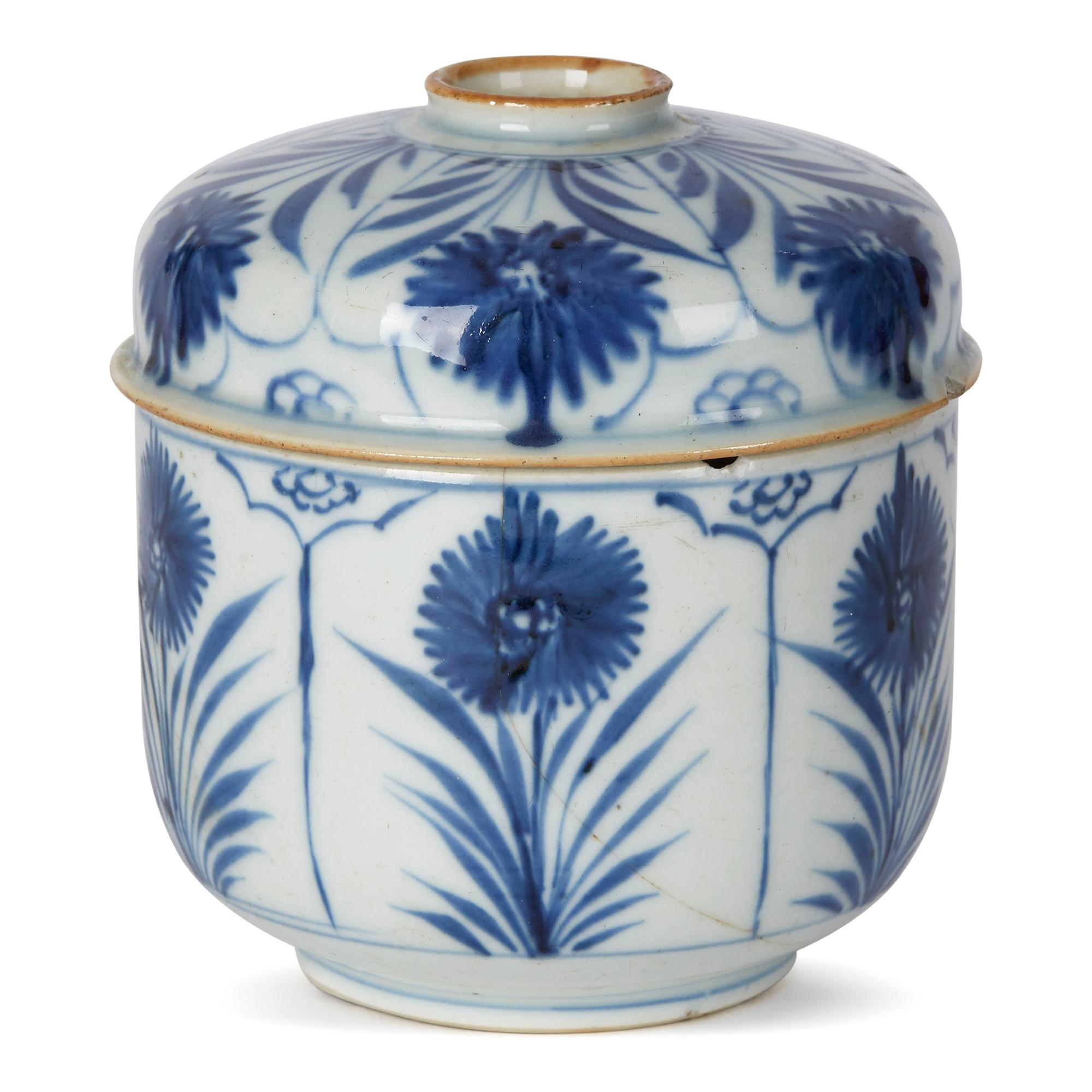 A fine antique Chinese export porcelain lidded pot and is well decorated in underglaze blue with hand painted blooms on tall leafy stems set within panels around the body and cover. The cover with a raised rounded handled with a brown stained rim.