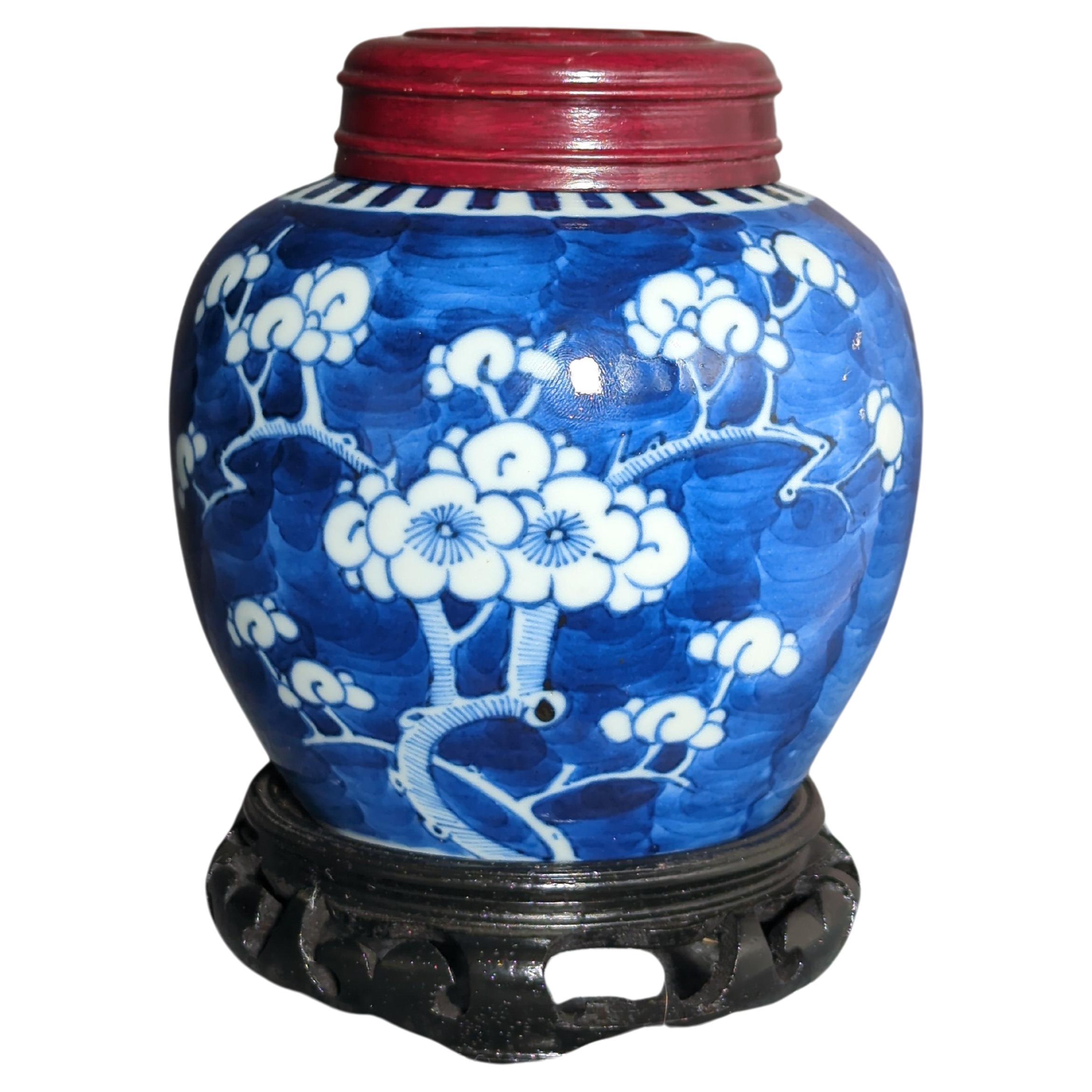 Antique Chinese late Qing dynasty blue and white ginger jar, reserve decorated in underglaze blue and white, with blooming prunus branches on underglaze blue wash ground, and double circle mark in underglaze blue within the footring

Comes with