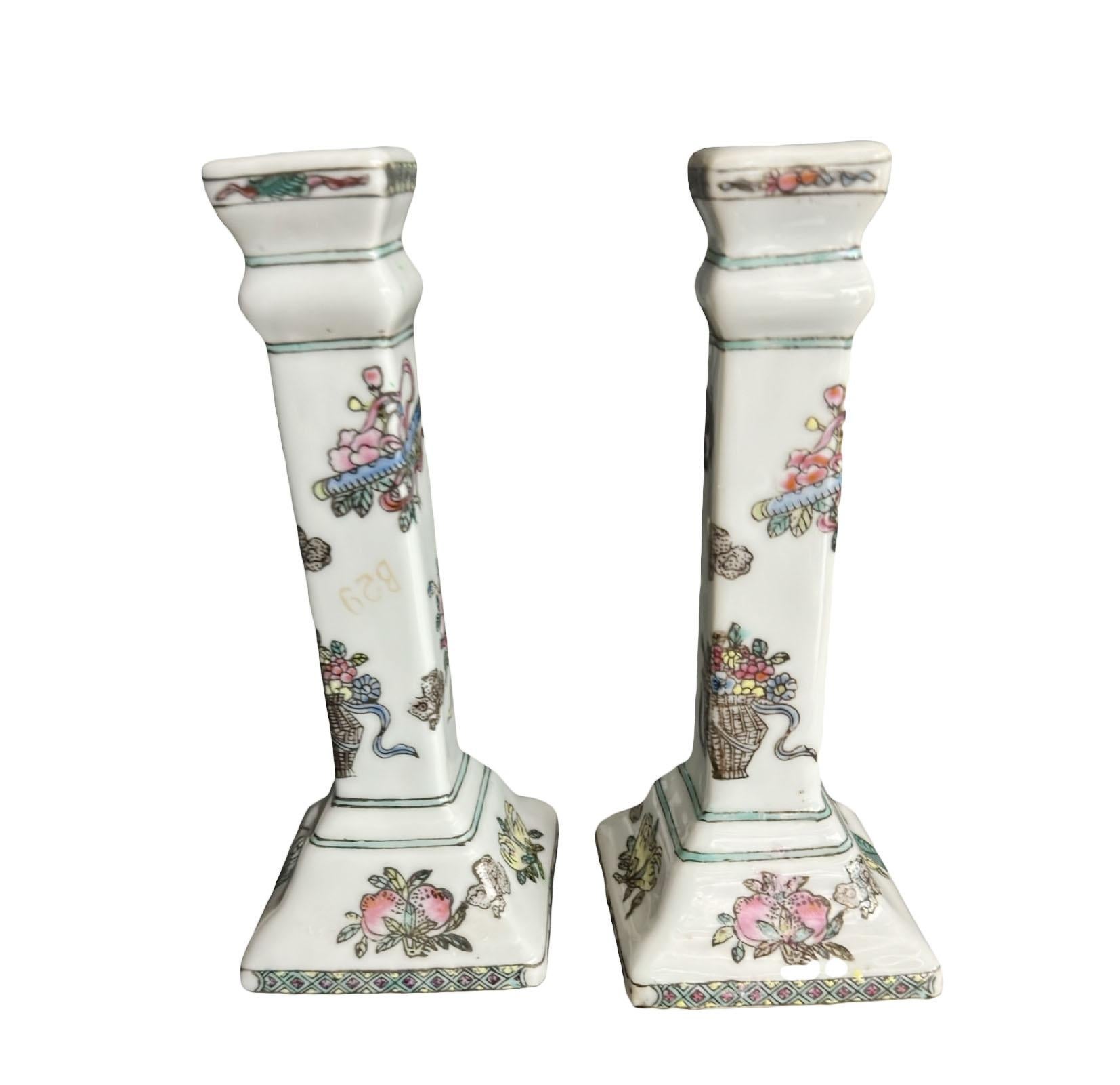 Coppia di candelieri in porcellana cinese dei primi del Novecento dipinti a mano con fiori rosa, gialli e blu con varie sfumature di fogliame verde. I disegni avvolgono i portacandele e sono molto belli. Perfetto per aggiungere un tocco di eleganza