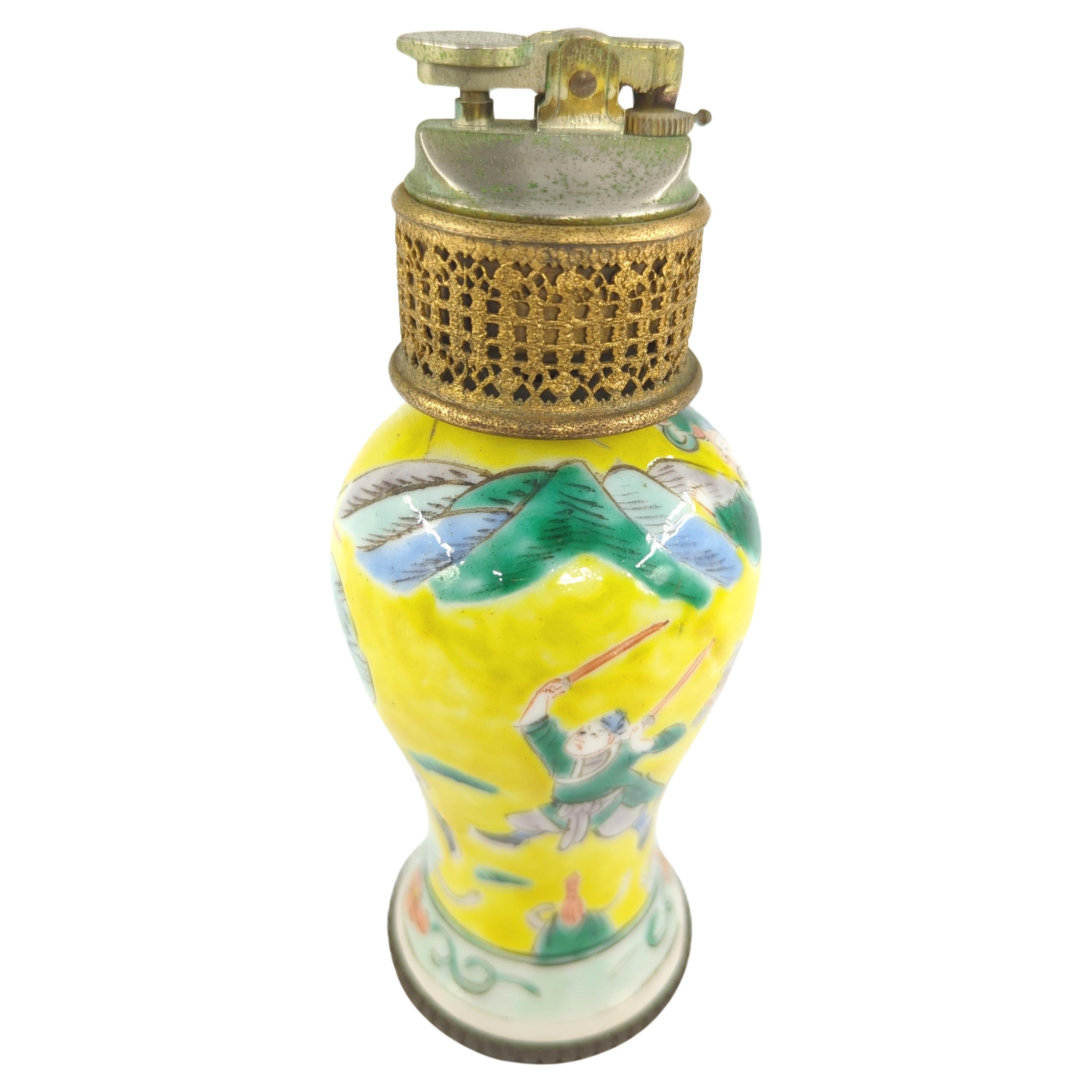 A small antique late Qing to early Republic Chinese porcelain meiping vase, ingeniously converted into a functional butane table lighter. The intricate brass mounting work dates from mid 20th century, this piece serves as a compelling intersection