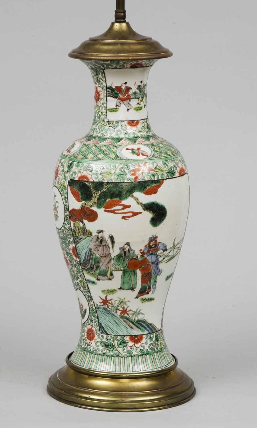 Chinese Famille vert porcelain baluster-shaped lamp mounted on a bronze base, the panels front and back are decorated with male figures, bamboo trees, rocks with overall design of flowers, swirling vines and leaves. Height is adjustable.