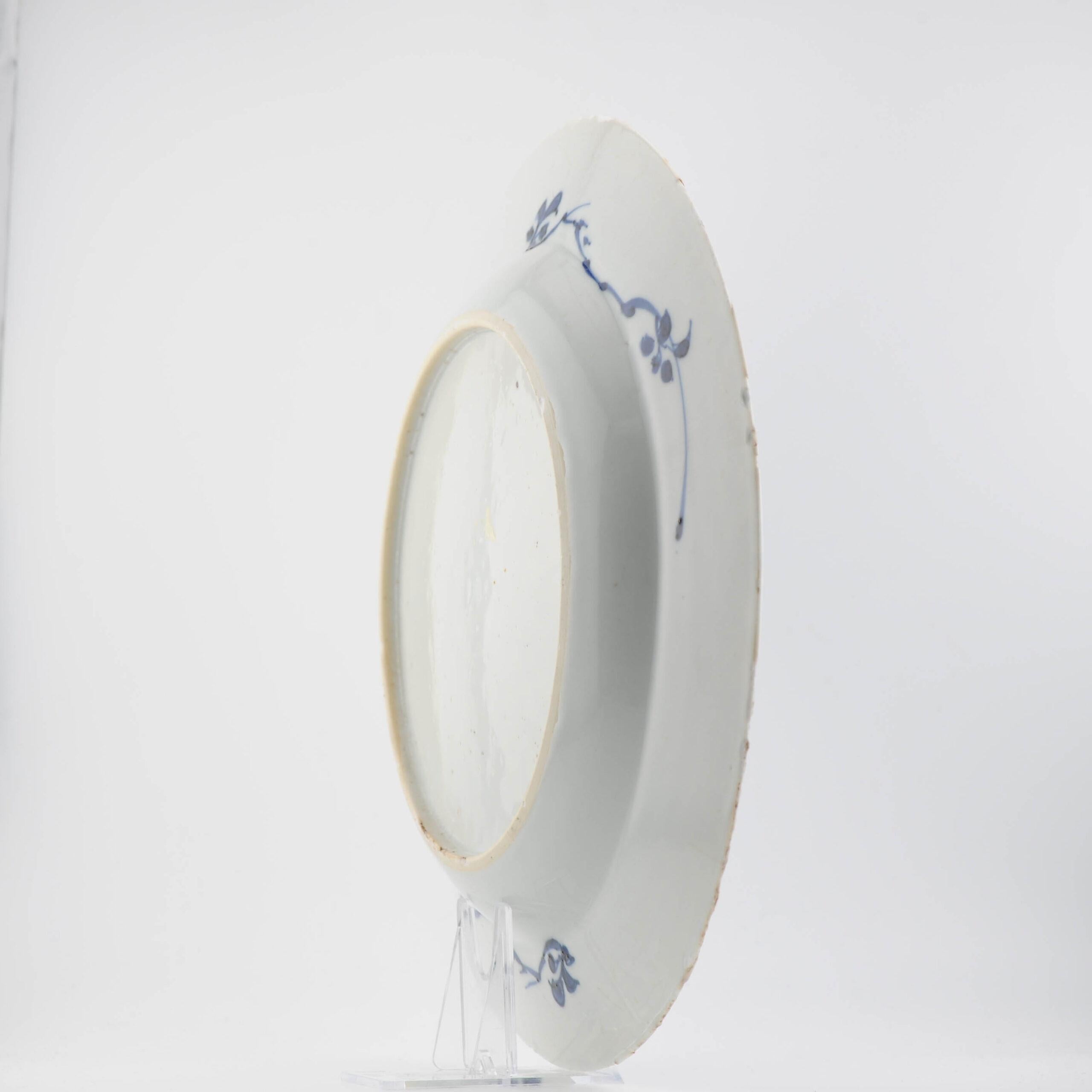 Plato de porcelana china del periodo Kangxi. El plato tiene motivos de flores y hojas estilizadas de color azul oscuro. En el borde del plato hay una decoración azul claro bajo vidriado de flores de loto estilizadas y zarcillos. También se