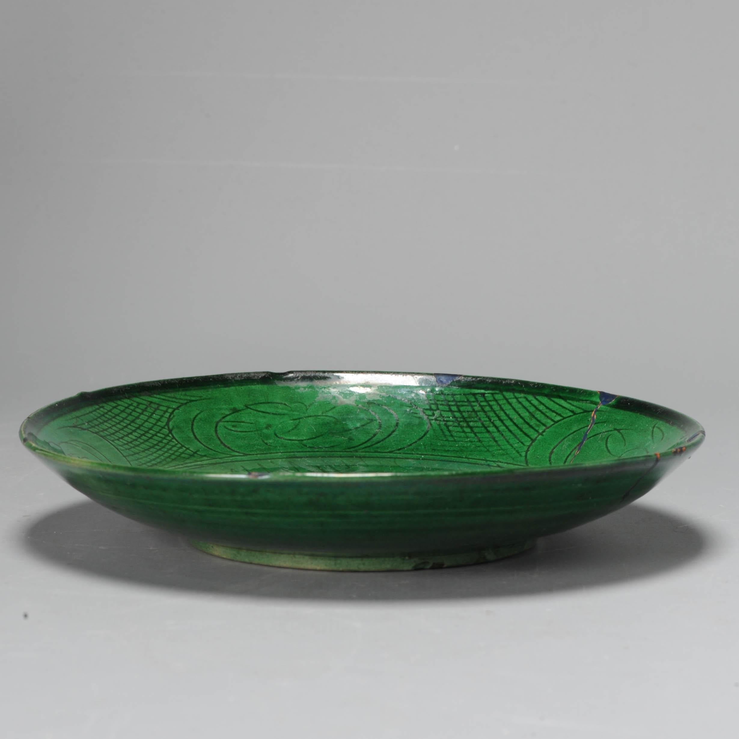 A very nicely decorated plate with beautiful Green Glaze and a carved underglaze scene of a Duck/Goose in a pond. Dated to the late Ming or transitional period.

The back without decoration but fully glazed.

We have found similar dishes (but with
