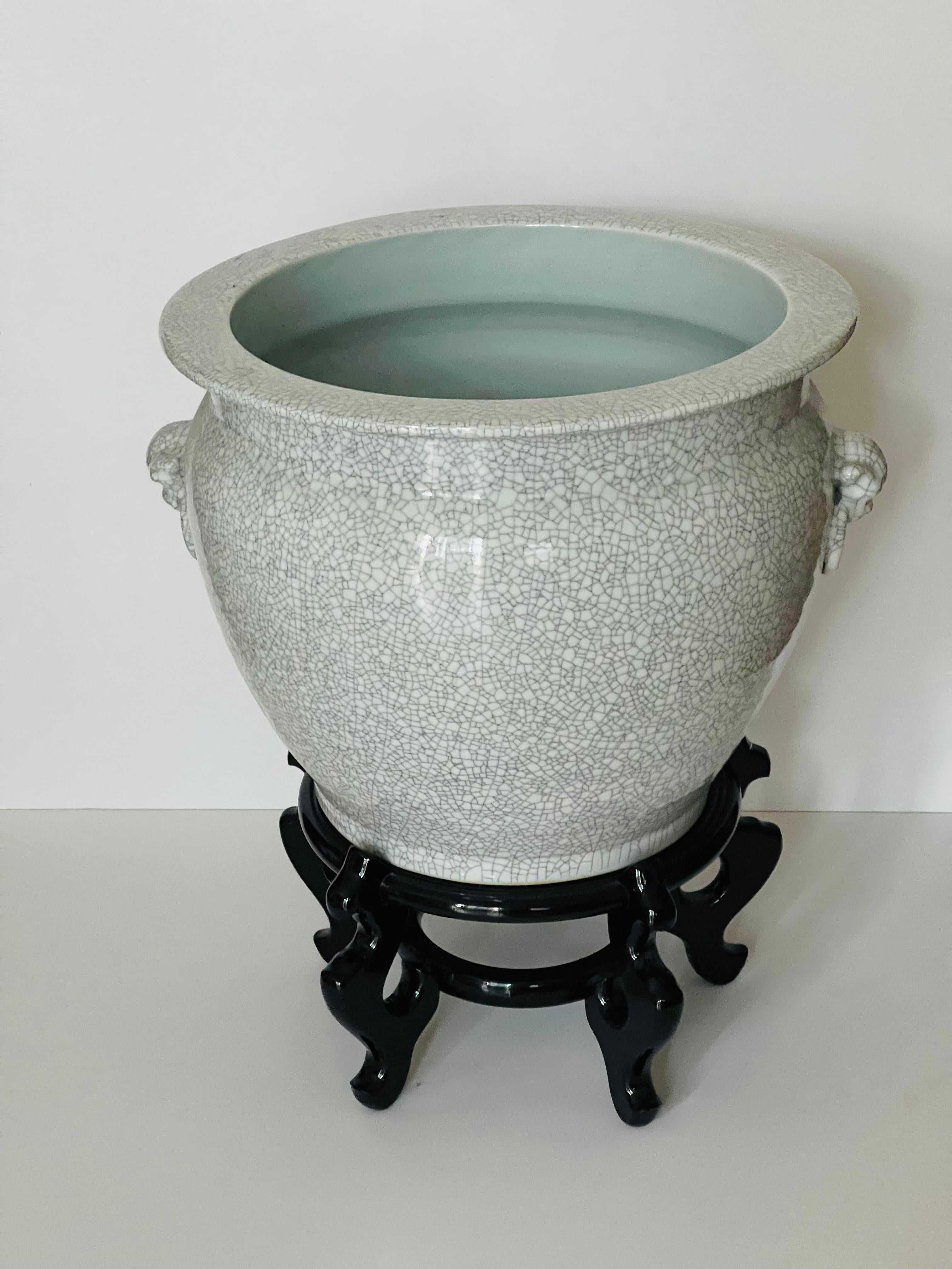 Ancien bol à plantes en porcelaine chinoise craquelée, grand et lourd, sur un support en bois laqué assorti.