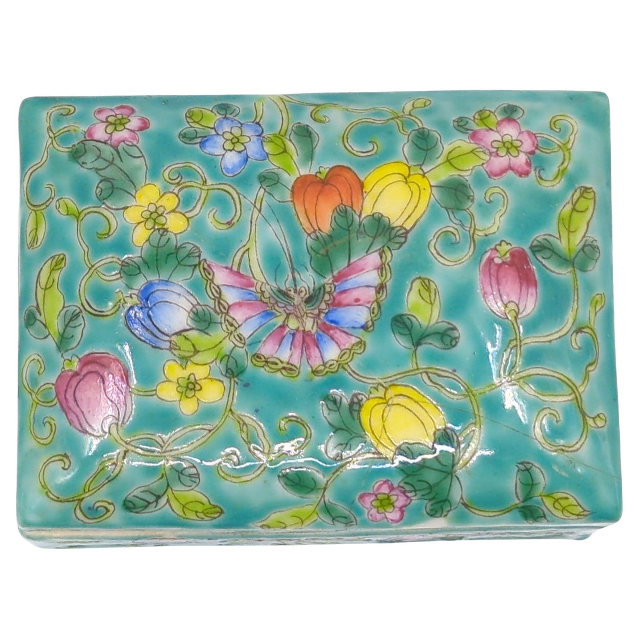 A wonderful antique Chinese famille rose fencai porcelain covered jewelry box, finely decorated with lively butterflies in colorful blossoms, scrolling vines and foliage, on turquoise ground. Bottom marked 