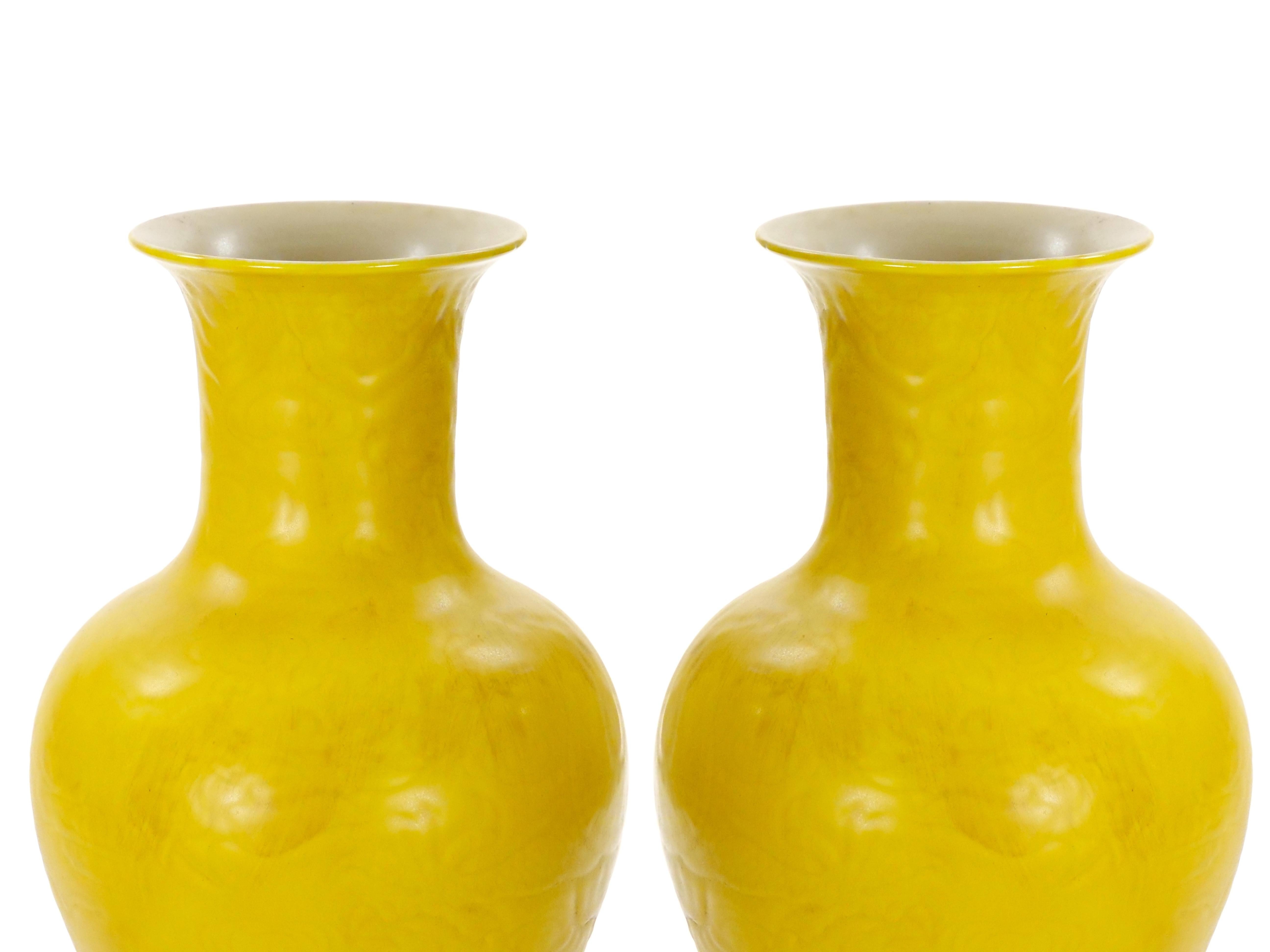 Ce magnifique vase ancien en porcelaine de Chine, qui se distingue par sa teinte jaune frappante et son motif complexe de dragon en relief, est une pièce décorative captivante datant d'une époque révolue. Le vase présente une forme classique de