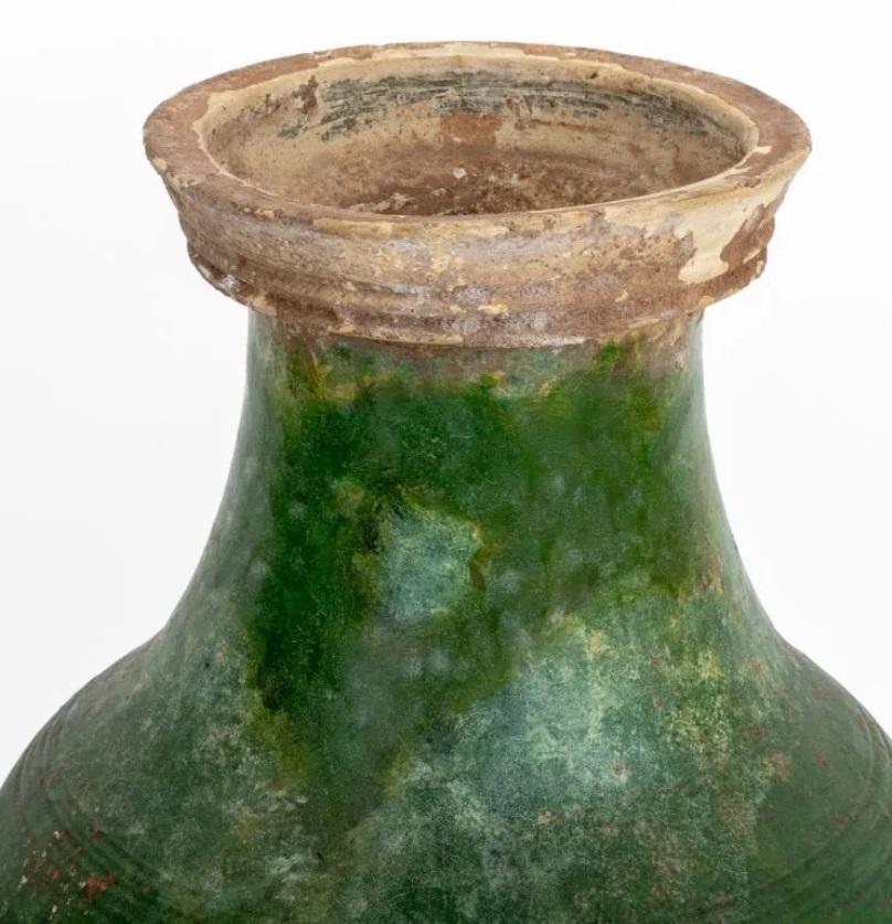 Antico vaso di ceramica cinese Hu, dinastia Han 

La form A di Hu  Il corpo e la spalla sono circondati da varie  bande di corde di arco che racchiudono una coppia di maschere taotie e maniglie ad anello fisso, ed è ricoperto da uno smalto verde