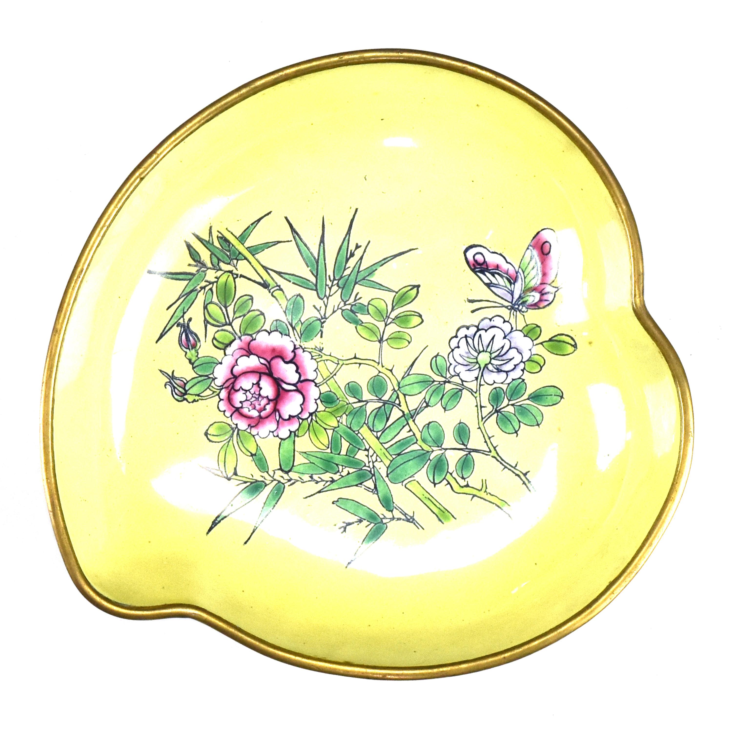 Ancien plat en forme de pêche en émail de Canton décoré de bambous, de roses et d'un papillon sur un fond jaune datant de la période Qing vers 1860.