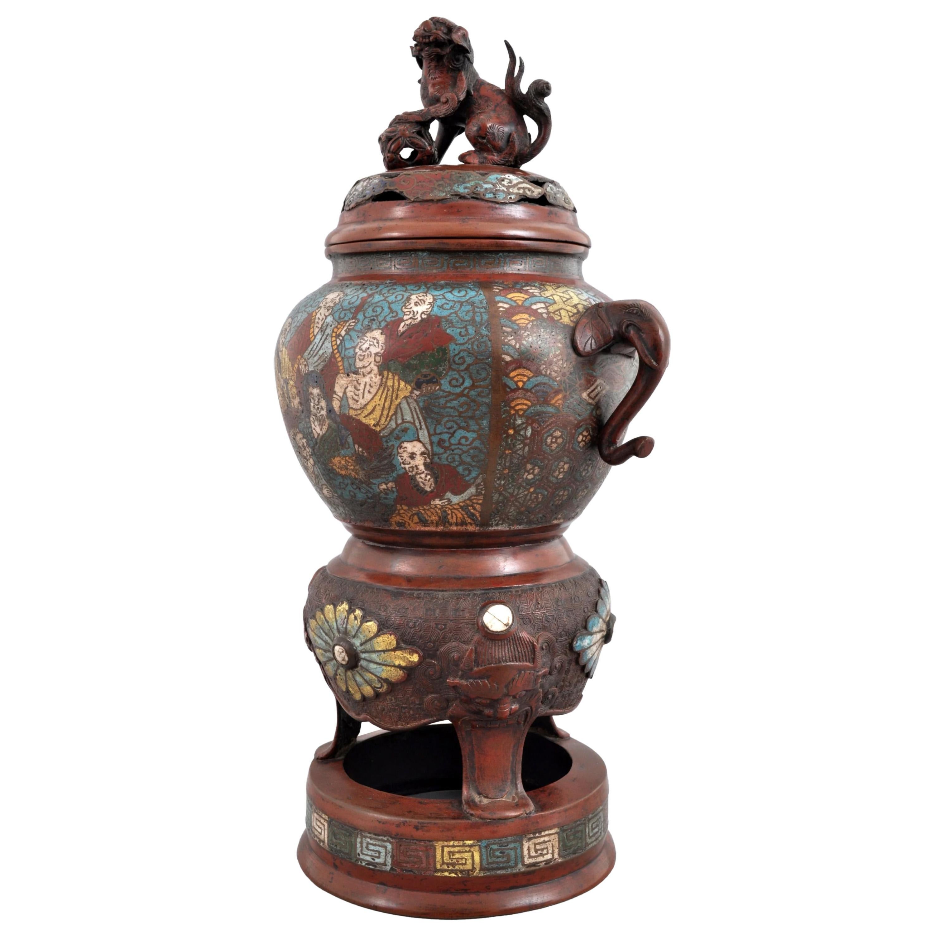 Ancien encensoir champlevé en bronze émaillé de style archaïque chinois, vers 1900. 
L'encensoir à couvercle est orné d'un fleuron en forme de chien de Foo mâle. Le dessous de l'encensoir est orné d'une décoration en émail représentant des immortels