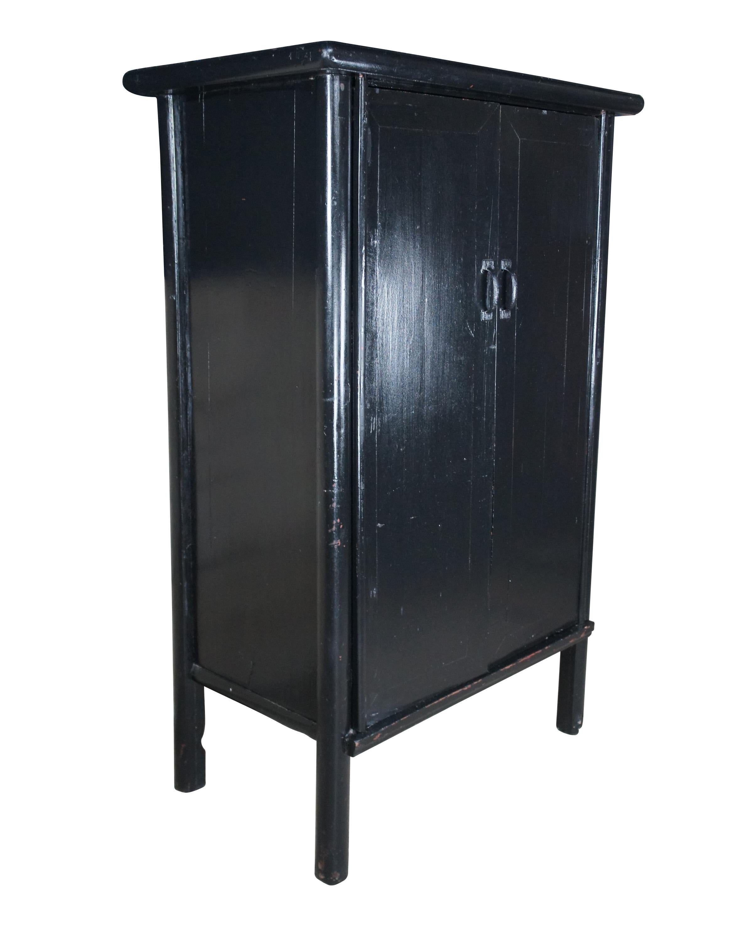Chinese black lacquer Qing Dynasty lines press or scholars cabinet, circa 1890s.  Features two doors with iron hardware that open to a natural finished interior with two large storage areas and two hand dovetailed drawers.  The cabinet is raised
