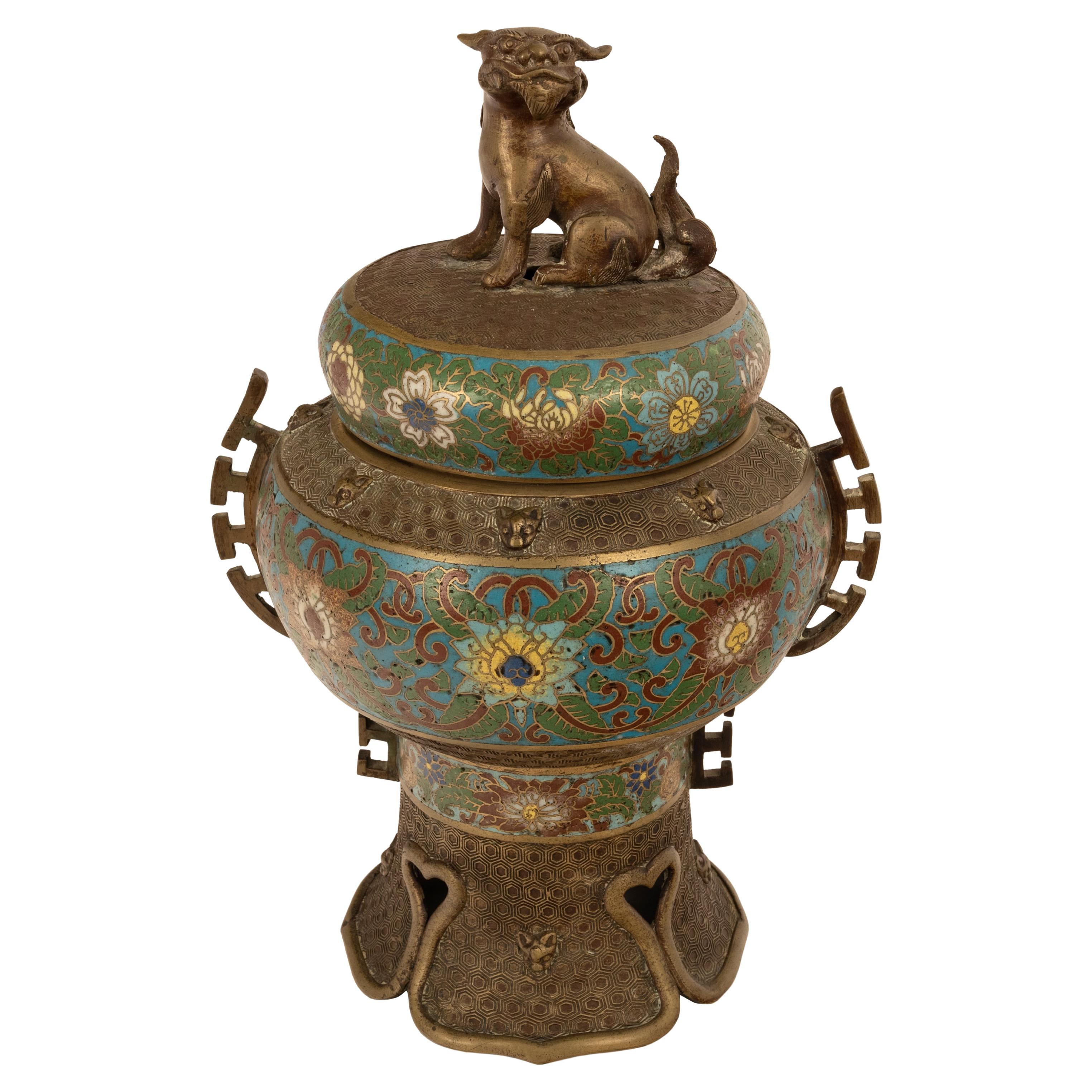 A good, large, antique Chinese Qing dynasty bronze and cloisonne censer, circa 1900.
The lidded censer having a Chinese lion (Shi) to the lid, the body and lid inlaid with floral cloisonne motifs, the sides having handles in an archaistic style,