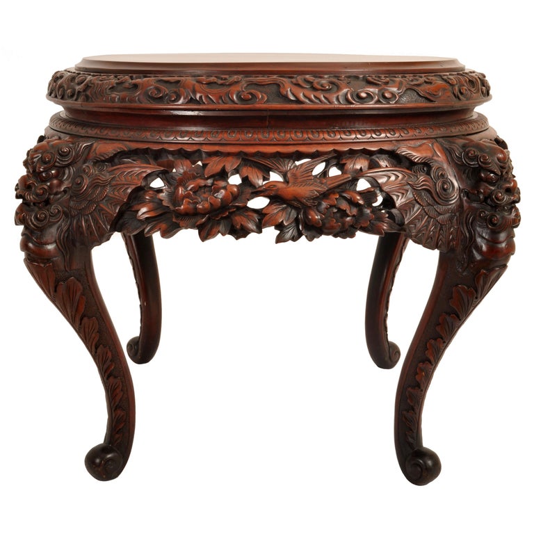 A very nice & finely carved antique Chinese elm center table, circa 1890.
The table having a circular top with a carved band of clouds and a carved band of lappets below, the body of the table having carved panels with lotus flowers, prunus & birds