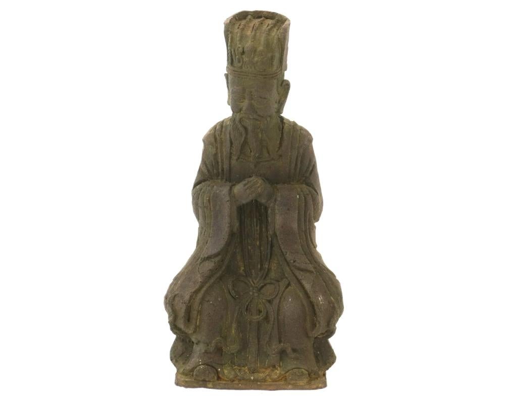An antique Chinese carved wood figurine, dating from the late Qing dynasty, portrays a priest in traditional attire. The intricate carving details capture the essence of the priests robes and accessories, reflecting the craftsmanship of the period.